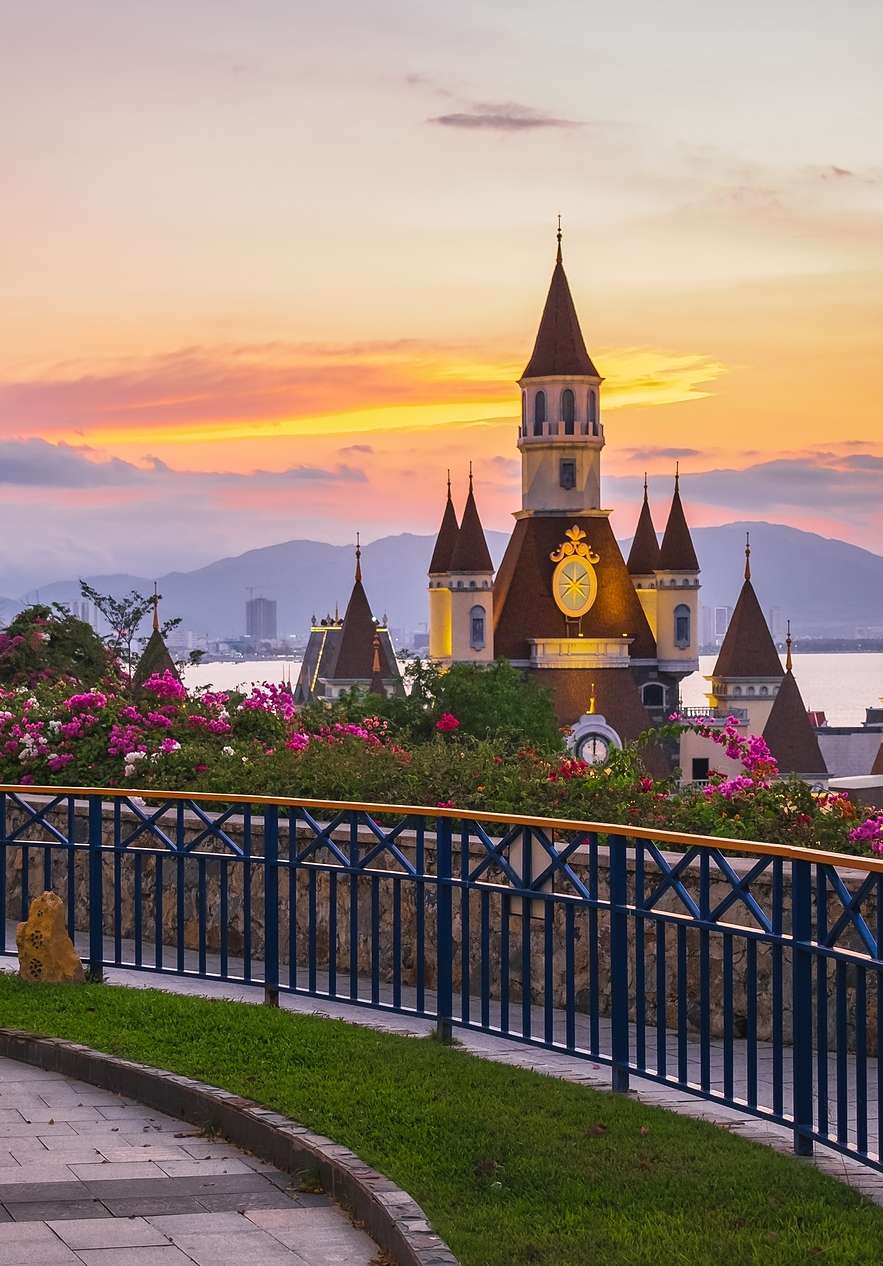 Panoramablick auf ein Schloss in einem Disney-Themenpark in Orlando, mit einem See und Bergen im Hintergrund