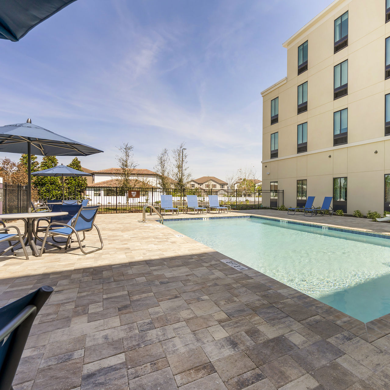 Außenpool im Pestana Orlando mit Stühlen und Tischen unter Sonnenschirmen sowie Liegen zum Entspannen