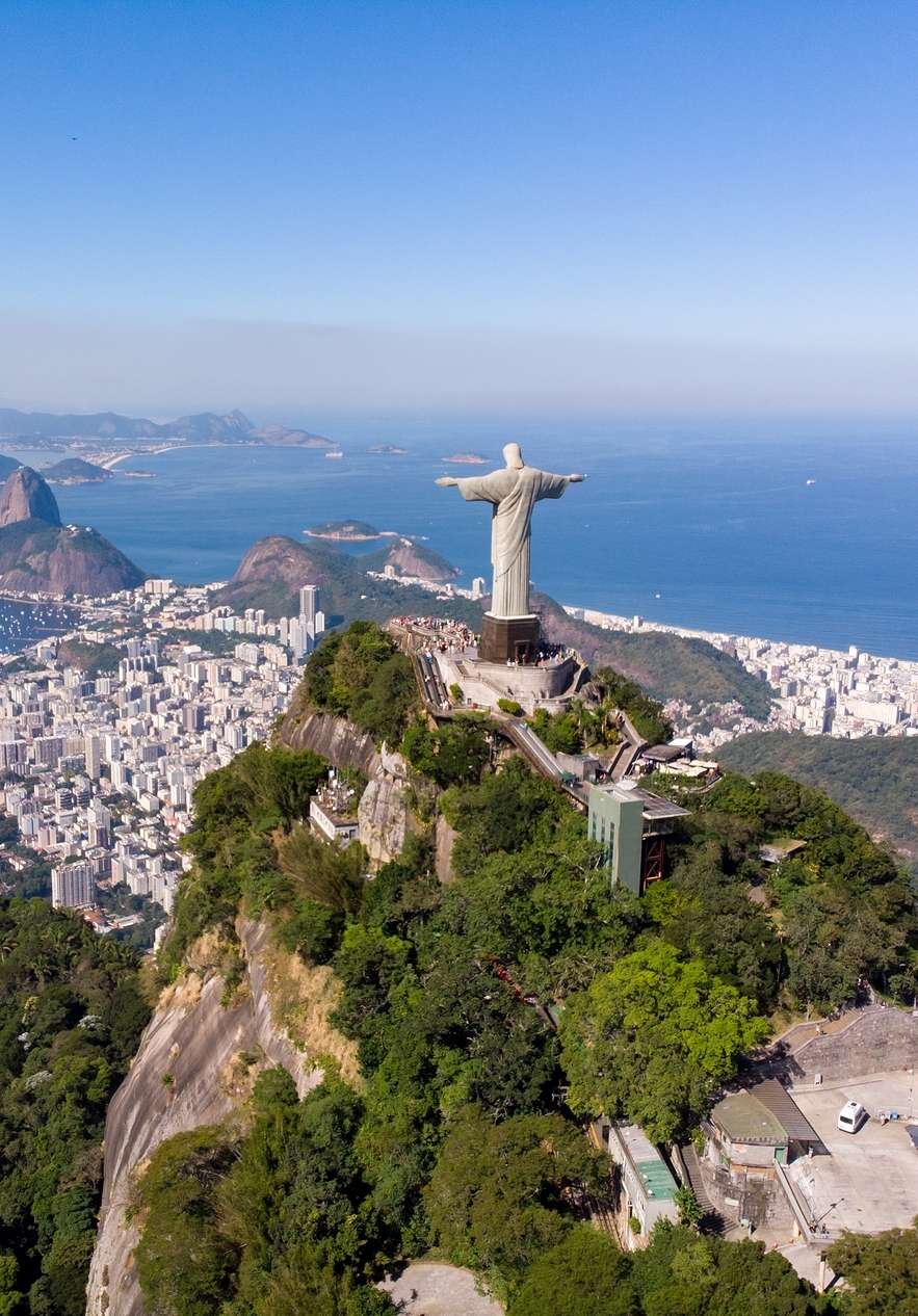 Statue des Cristo Redentor auf dem Corcovado, einem der bekanntesten Berge in Rio de Janeiro, mit Meer im Hintergrund