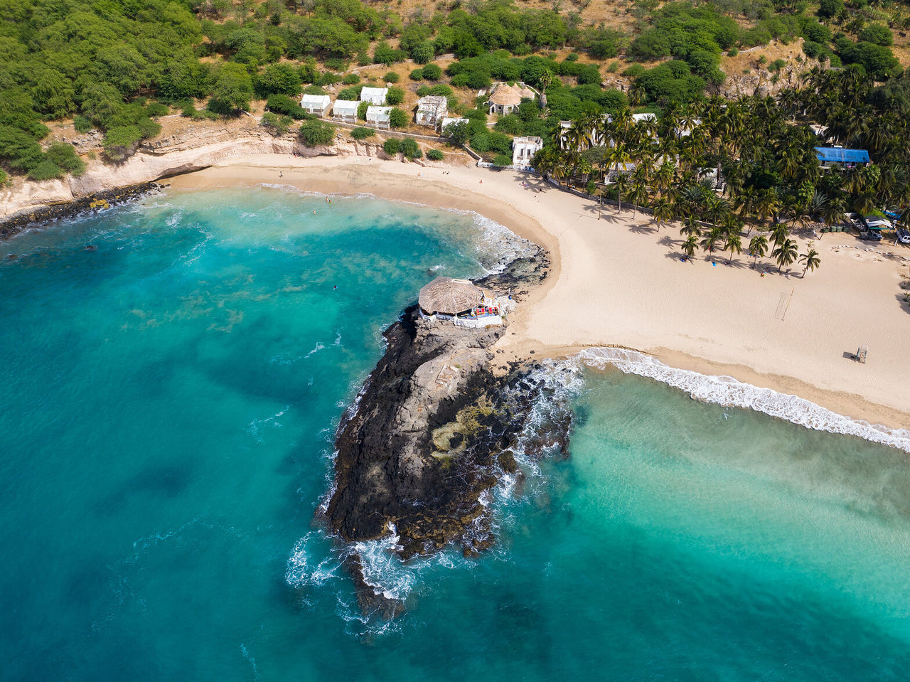 Explore Hotels in Cidade da Praia with an aerial view of a turquoise bay, sandy beach and palm trees