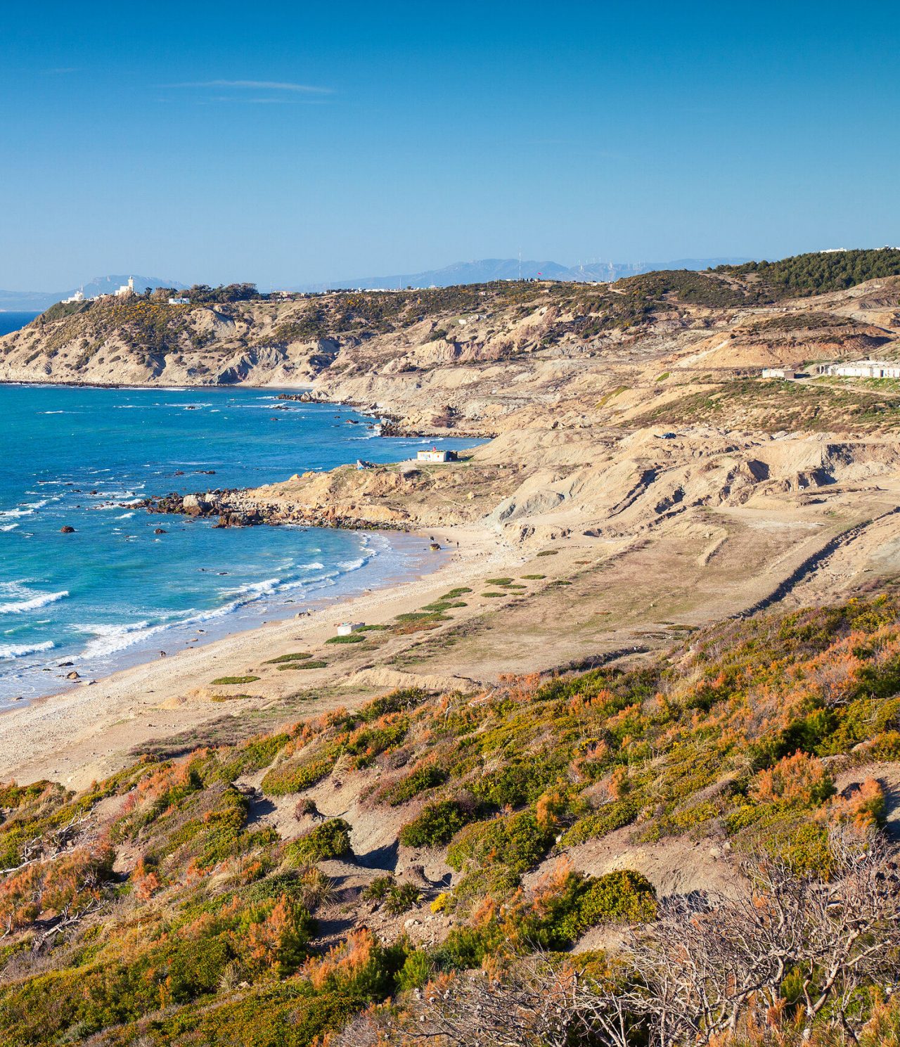 Vista de cima das praias em Tânger onde se vê as ondas do mar e toda a envolvência verde à volta da praia
