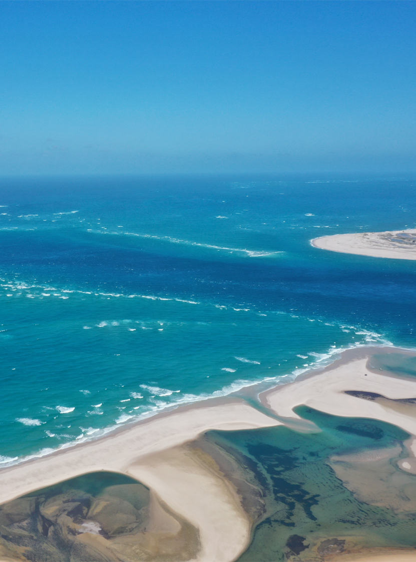 Stunning aerial view of Bazaruto Bay, with crystal-clear waters, white sand dunes, and coral reefs
