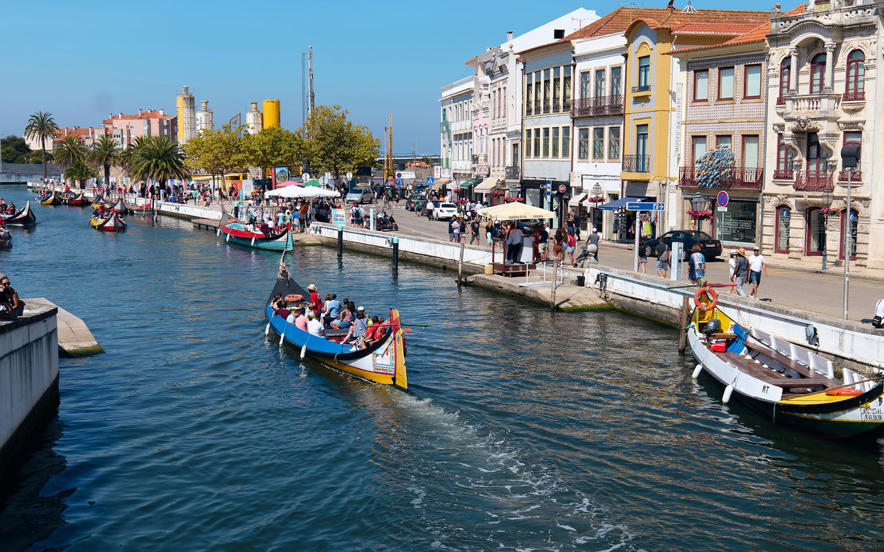 Explore Hotels in Central Portugal featuring colorful canal boats beside lively waterfront buildings
