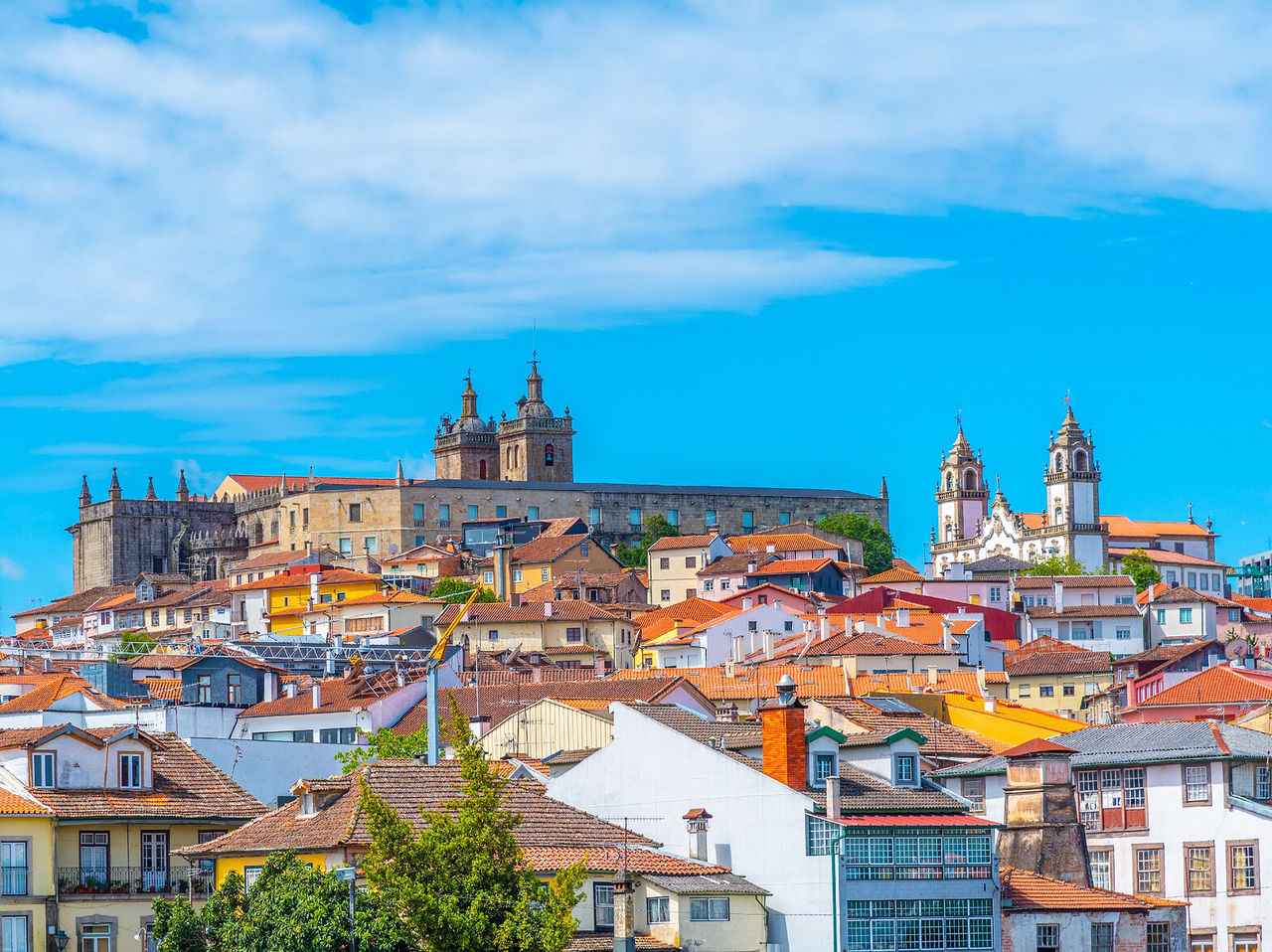 Explore Hotels in Central Portugal featuring historic churches and tiled rooftops beneath blue skies