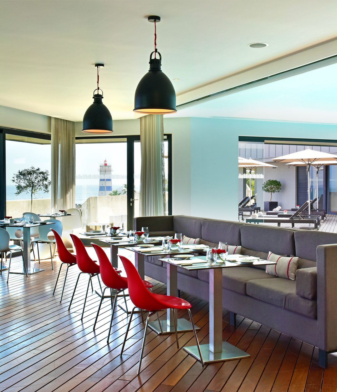 Restaurant Maris Stella in a 5-Star Hotel in Cascais, features gray sofas, red tables, and chairs