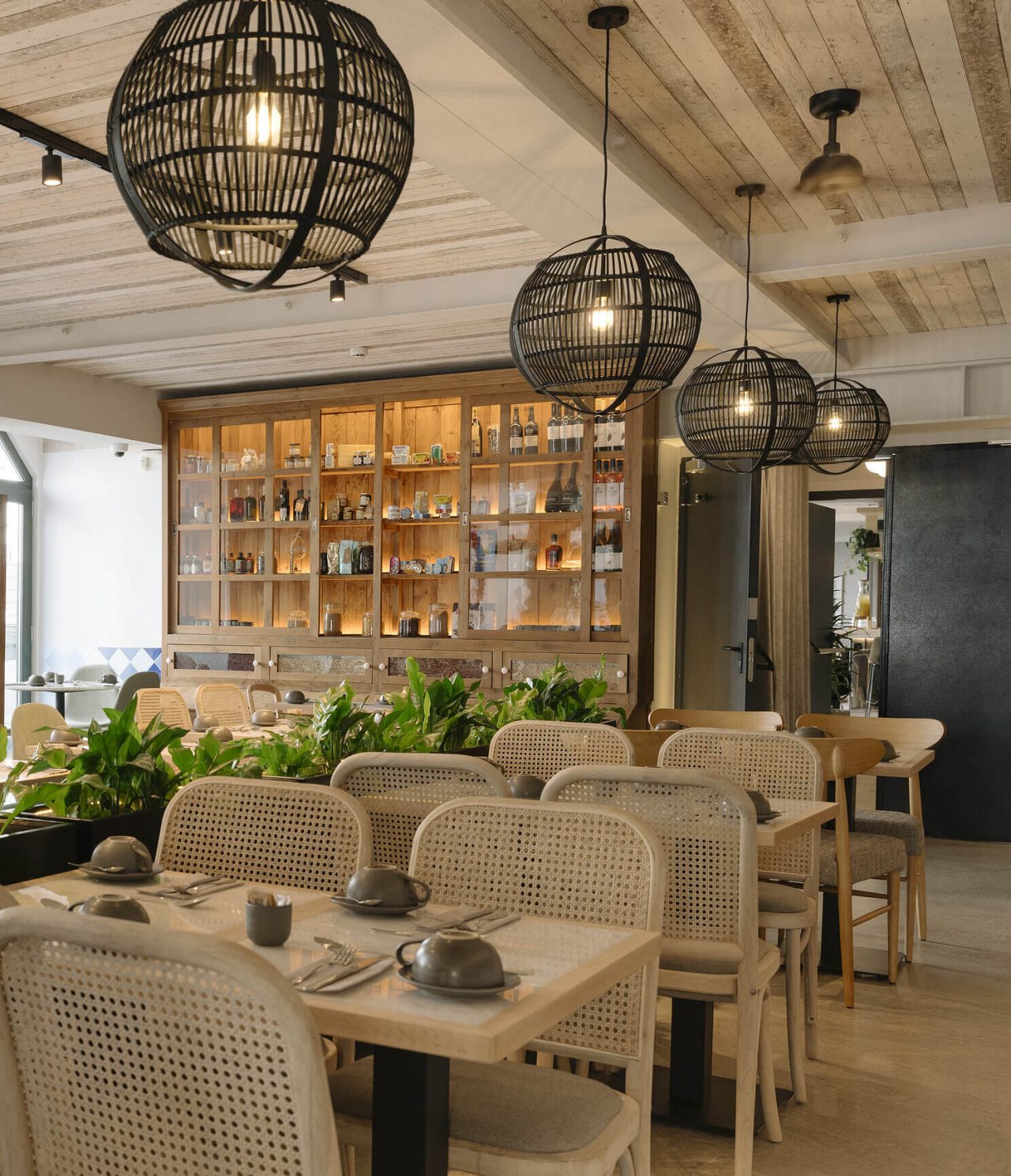Olive restaurant at the hotel in downtown Lisbon has several tables, plants and modern decoration