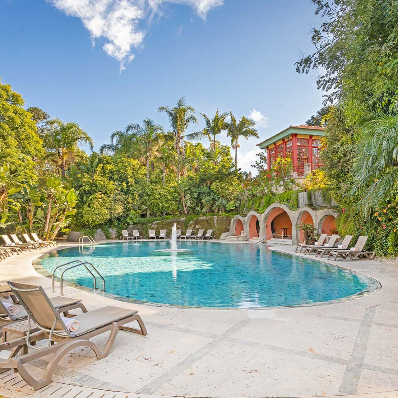 Pestana Palace Lisboa, Palace Hotel in Lisbon, with Pools and Spa featuring a curved outdoor pool and palms