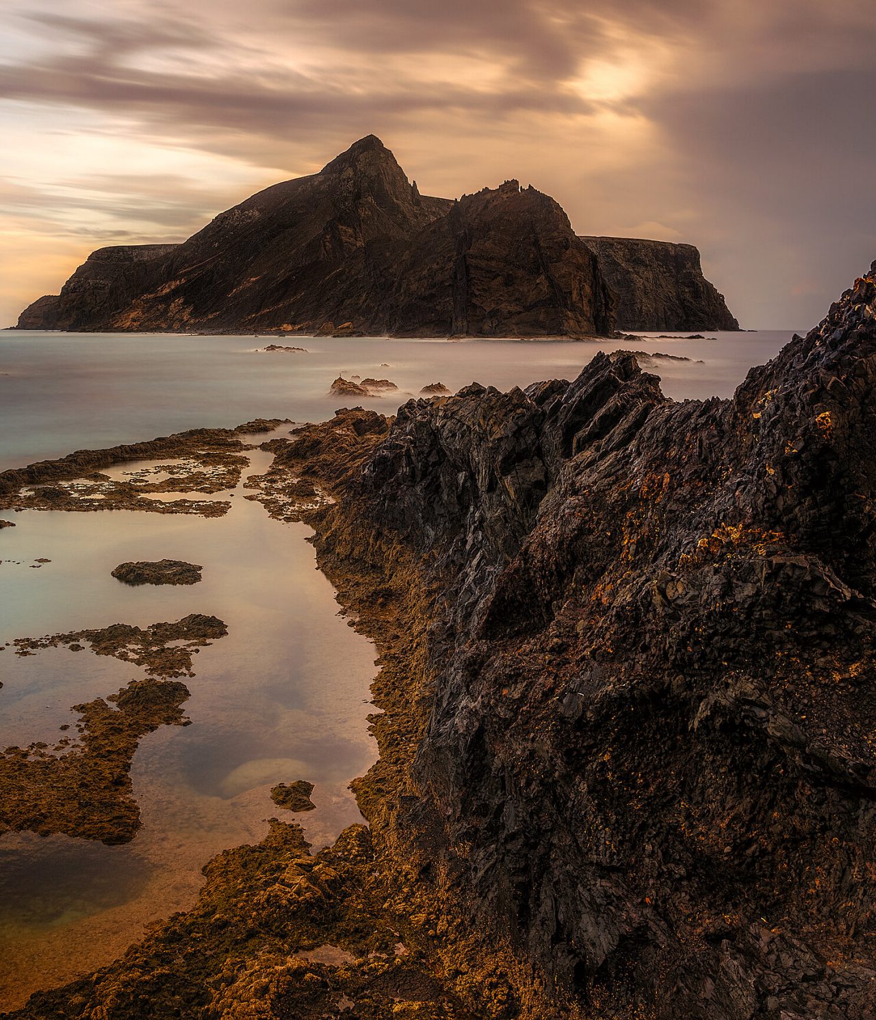 View of the rocky coast of Porto Santo Island, Madeira, with a rocky island in the background