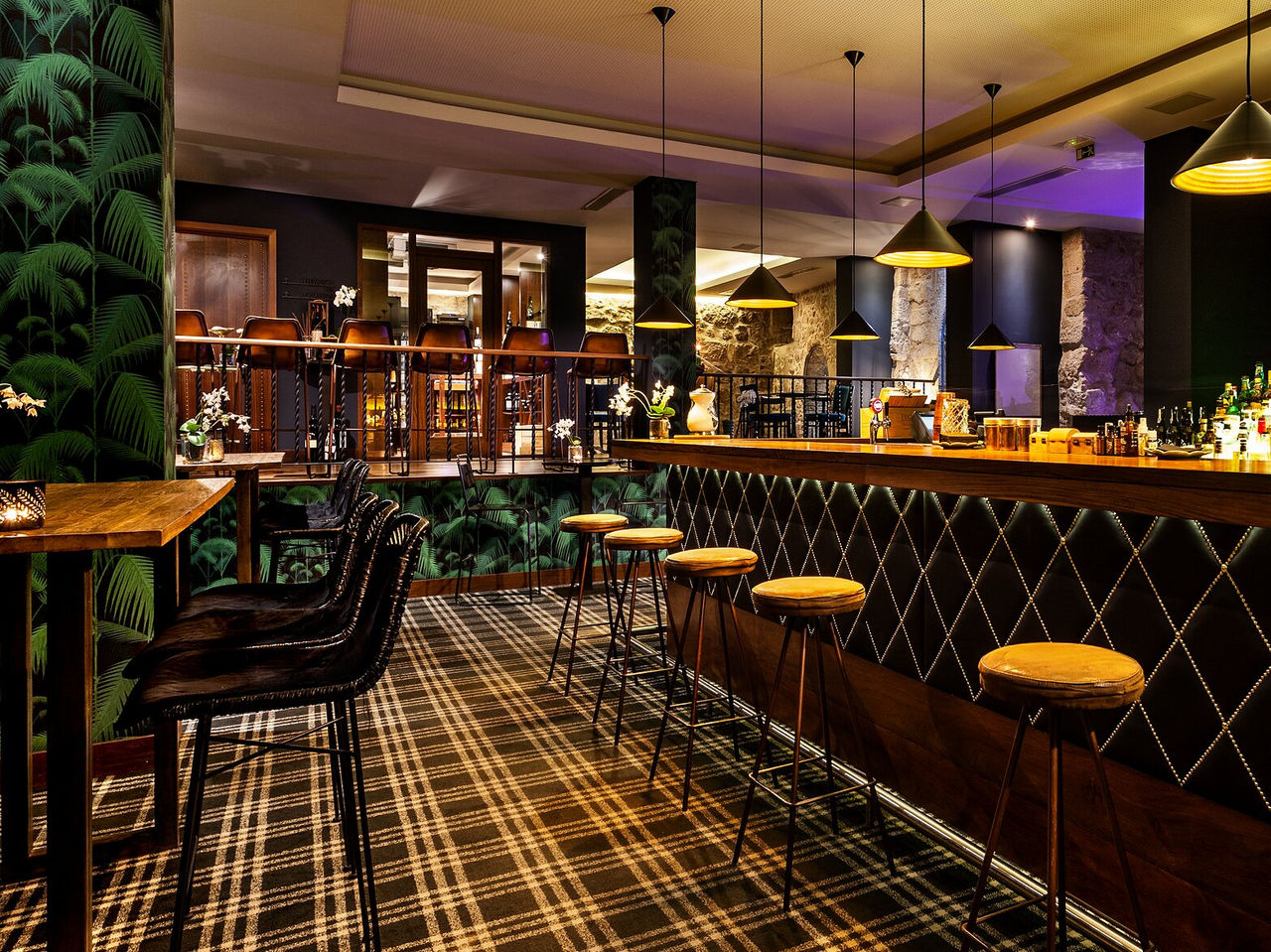 The Rib Bar, of the 5-Star Hotel in the Center of Porto, has a bar with an elegant atmosphere and dark tones