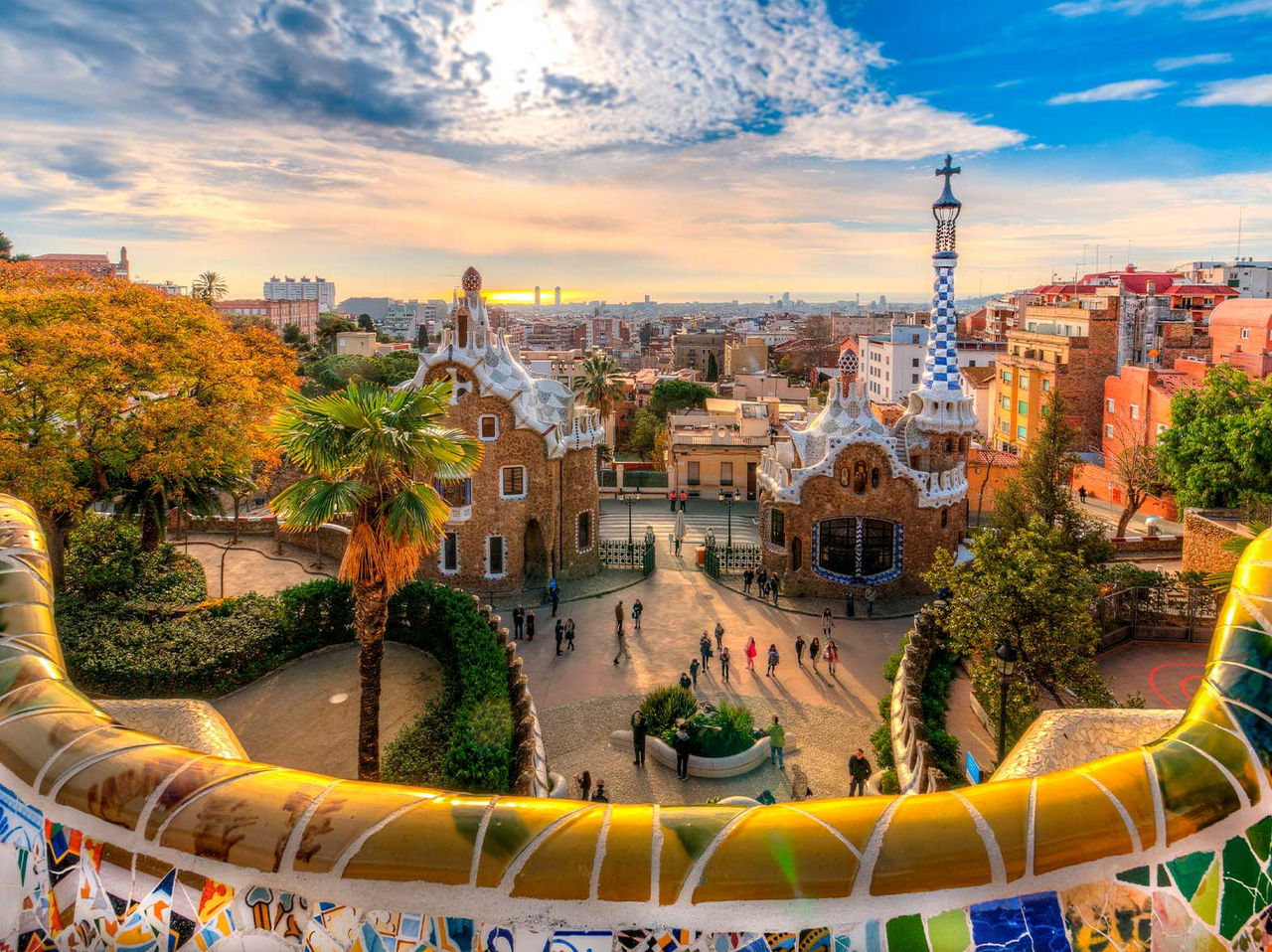 Panoramic view of Park Güell in Barcelona, with its iconic Gaudí constructions, surrounded by gardens