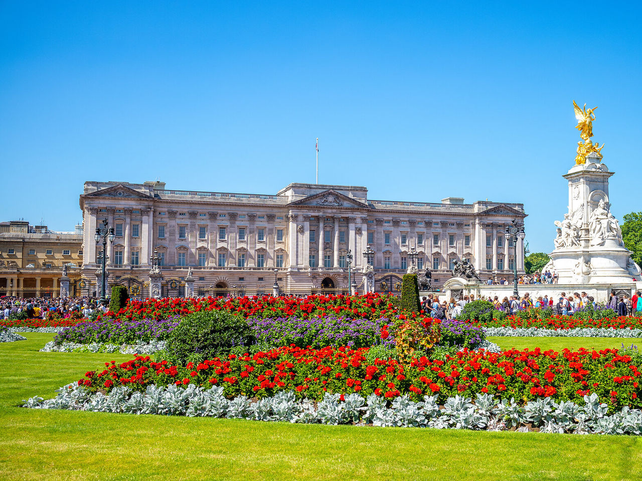 Explore Hotels in London featuring Buckingham Palace beside colorful flower gardens and the Victoria Memorial