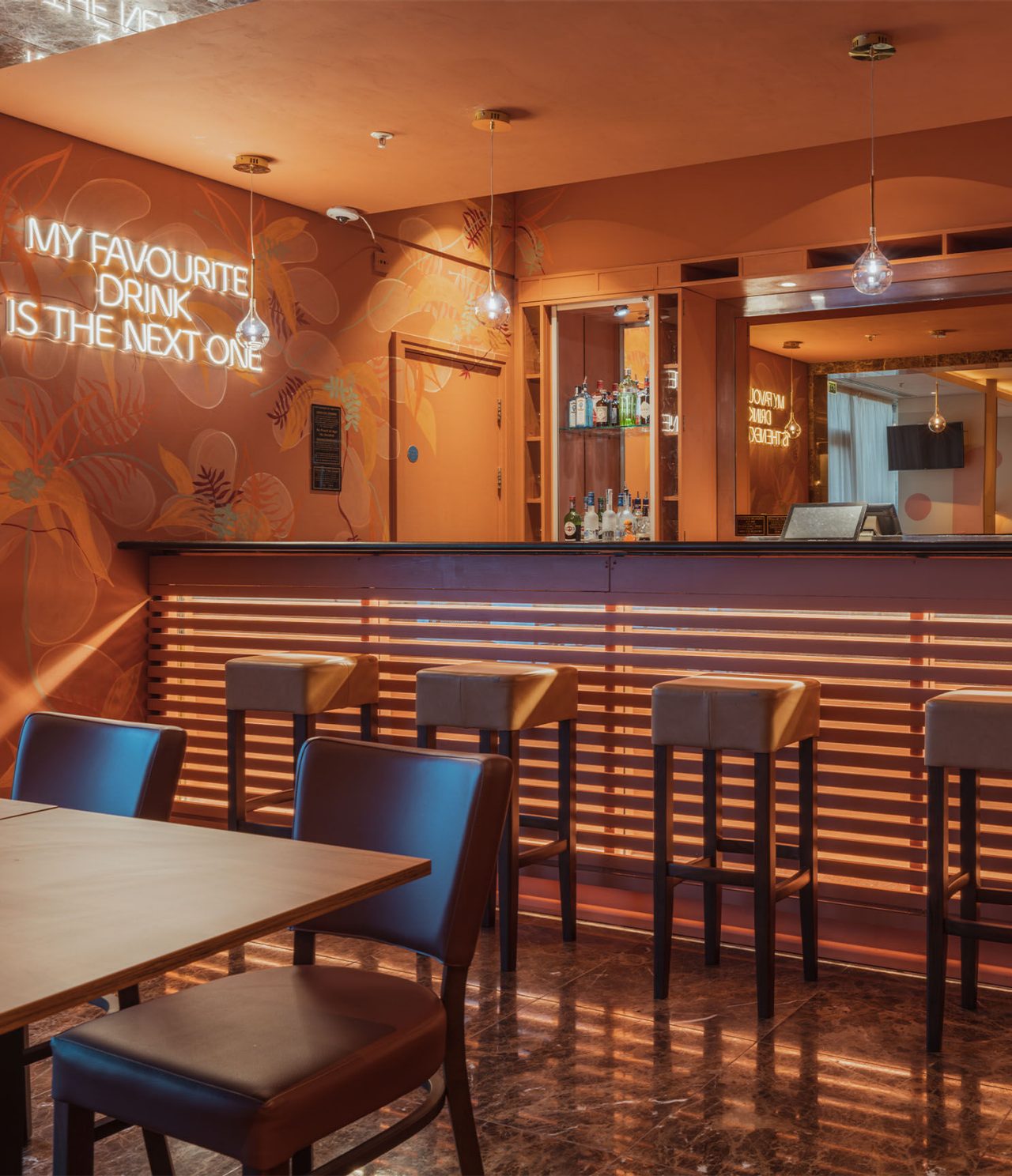 The Bridge Bar has a counter with high stools and an LED wall light