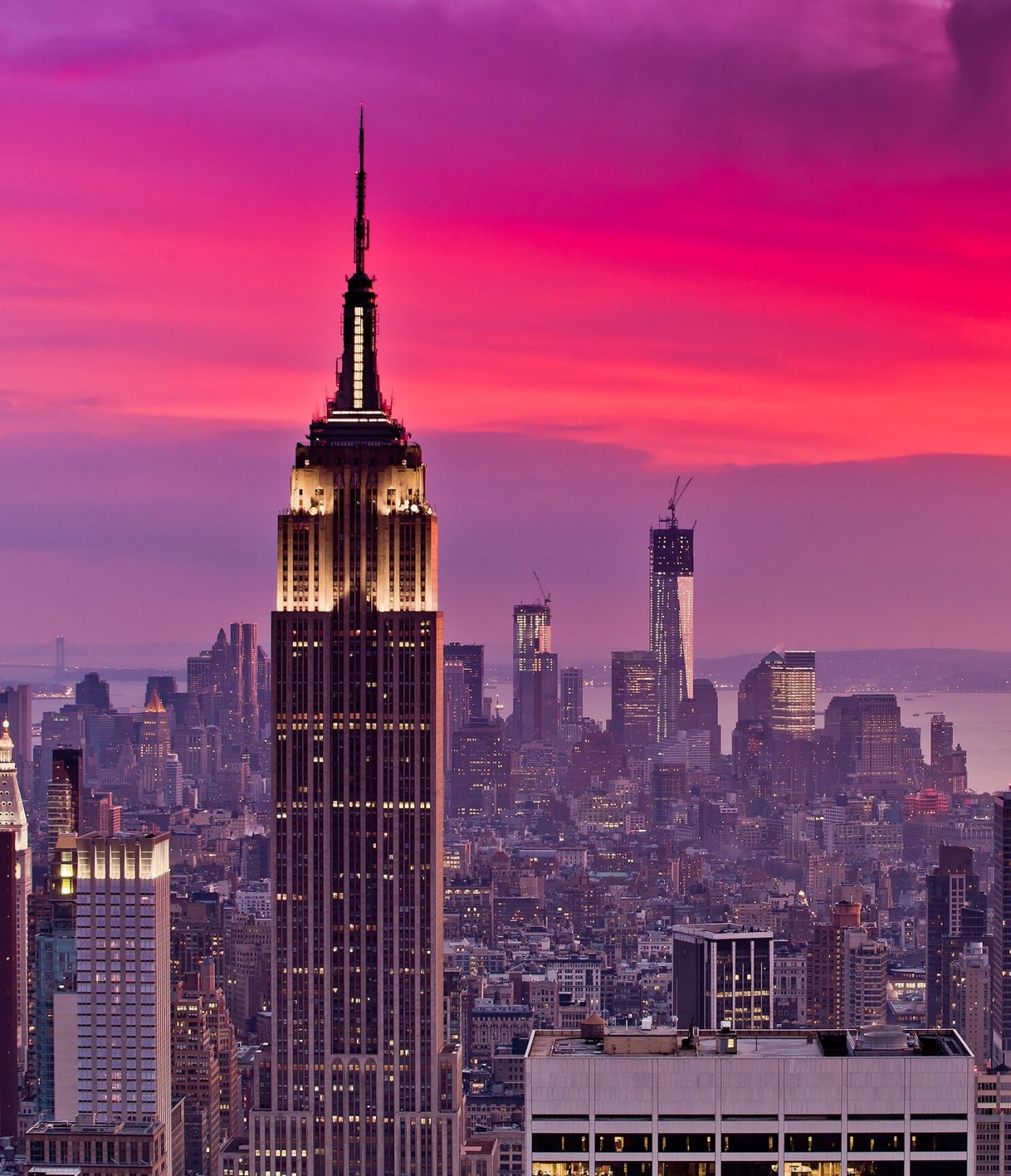 Explore Hotels in Downtown Manhattan, New York featuring the Empire State Building beneath a vivid pink sunset