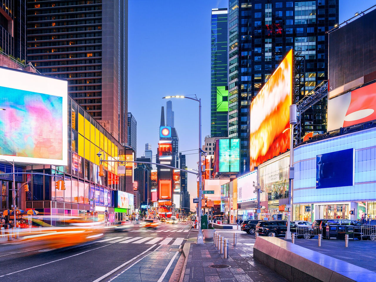 Explore Hotels in Downtown Manhattan, New York featuring bright billboards and busy evening streets
