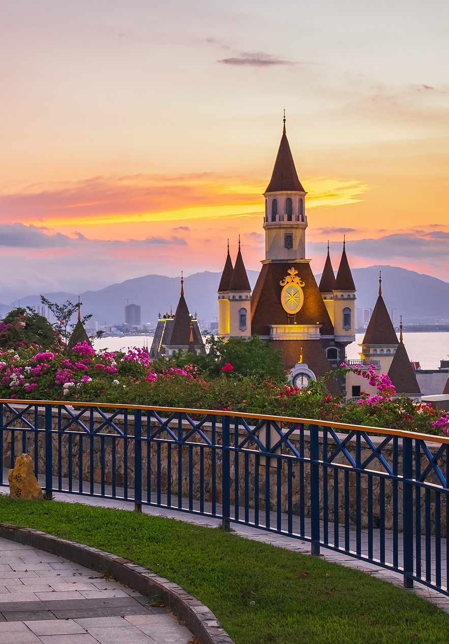 Panoramic view of a castle in a Disney theme park in Orlando with a lake and mountains in the background