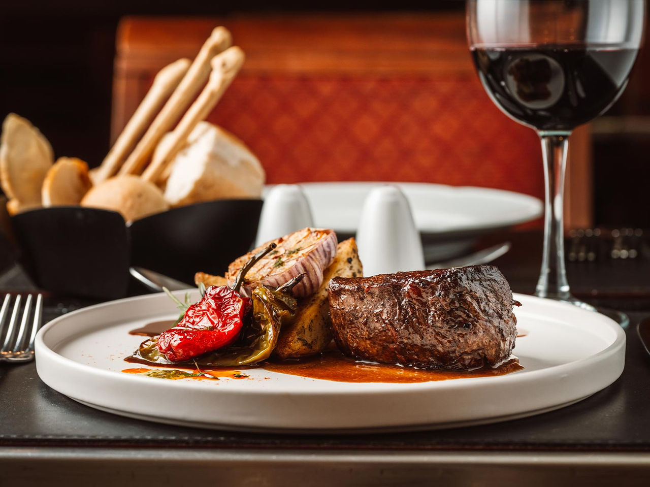 Restaurant at Pestana Buenos Aires Premium Hotel in Buenos Aires featuring steak, roasted vegetables and red wine