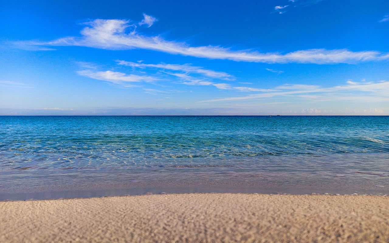 Explore Pestana Hotel Group featuring calm turquoise sea, sandy shoreline and wide blue sky with clouds