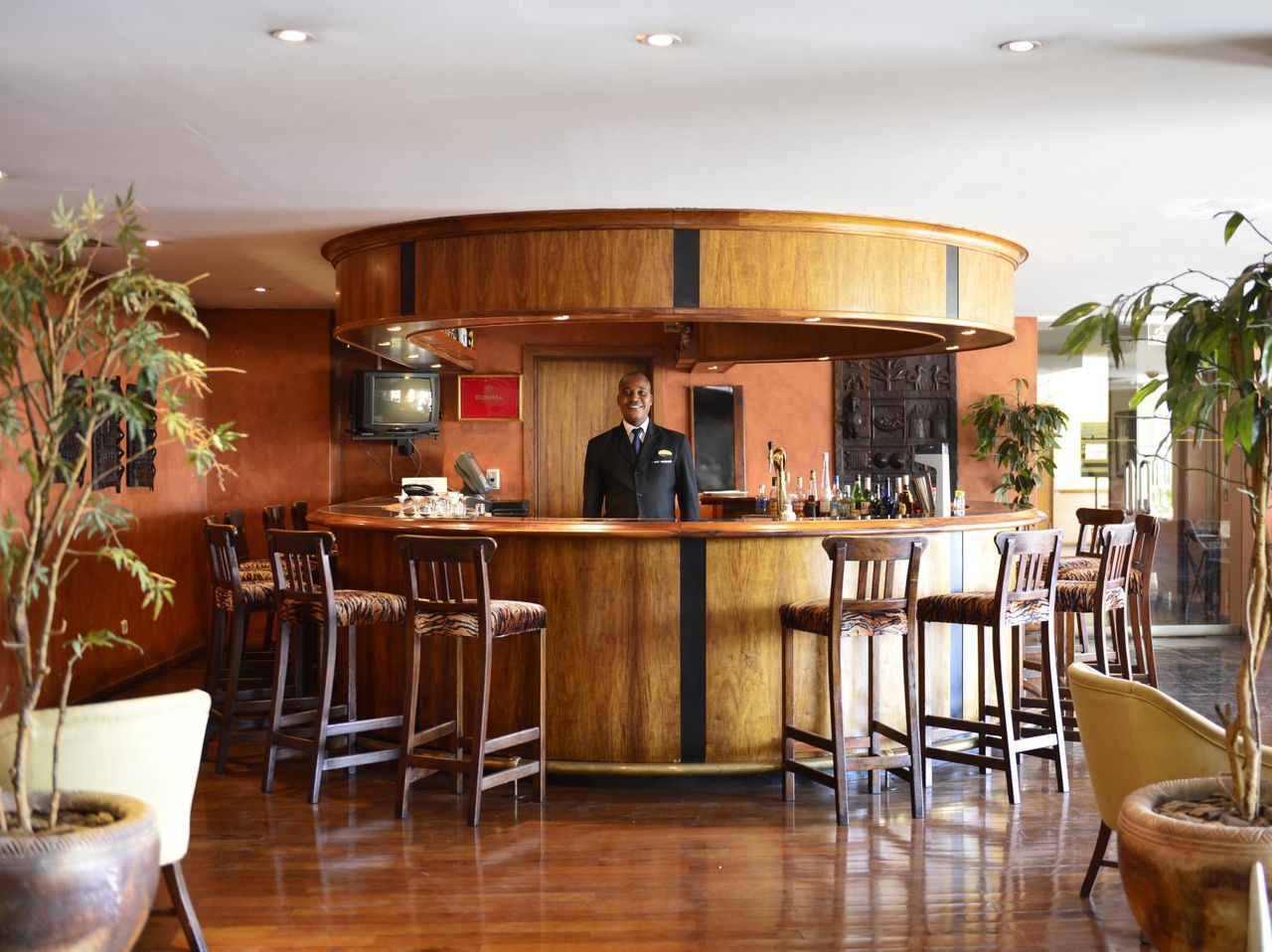 Bar del Pestana Rovuma Hotel en el Centro de Maputo, con barra circular de madera y taburetes altos
