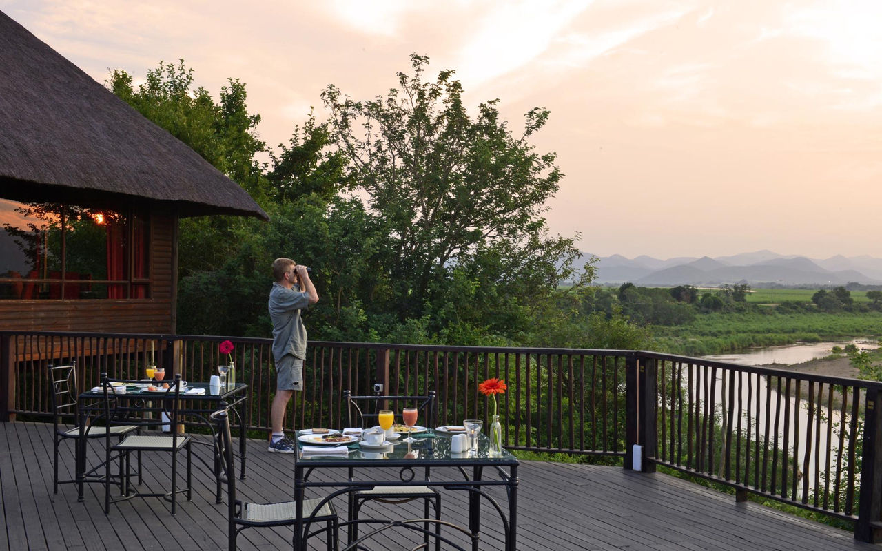 Pestana Kruger Lodge, hotel de 4 estrellas en Kruger Park, con mesas en el balcón para comidas y avistamiento de animales