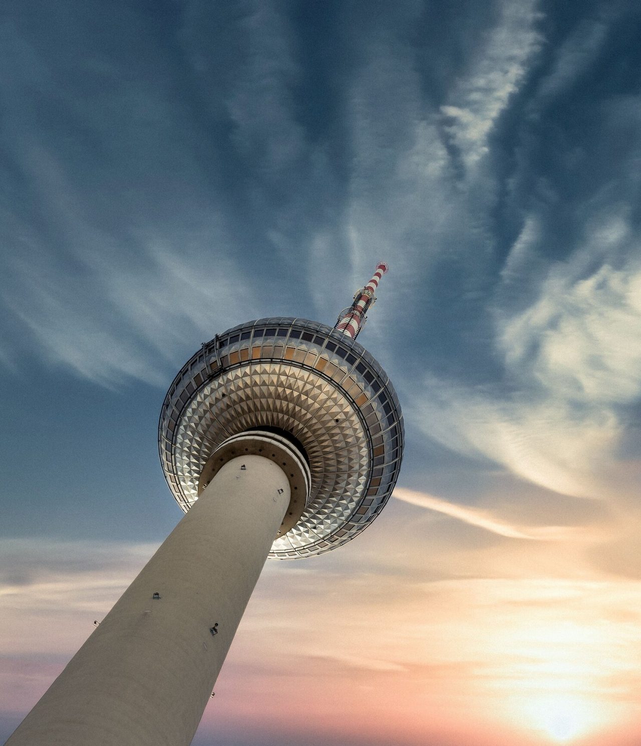 Explora Hoteles en Berlín con vistas a la torre de televisión iluminada bajo un cielo amplio al atardecer