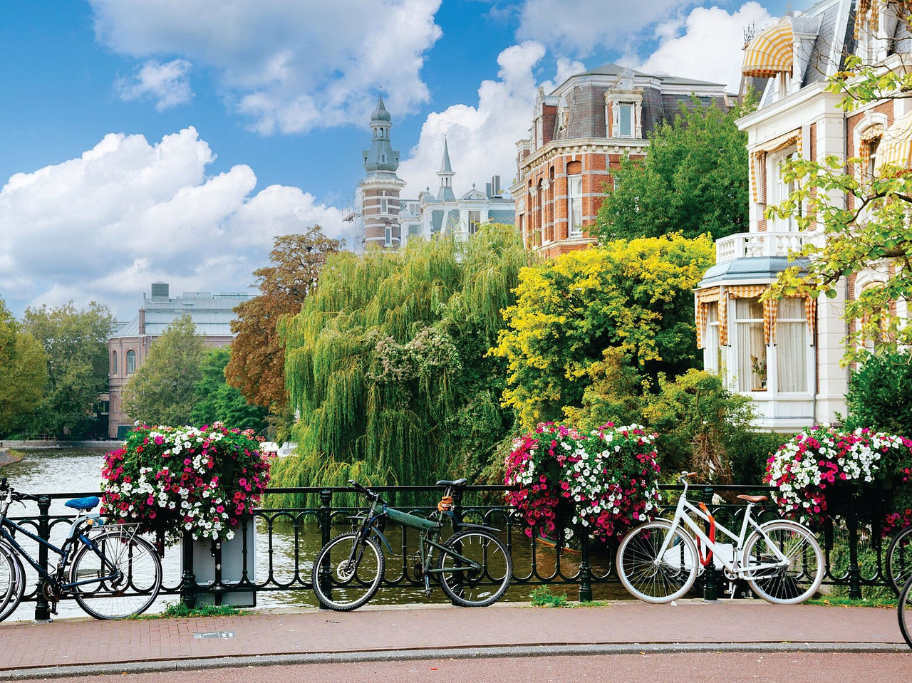 Explora Hoteles en Ámsterdam con vistas a bicicletas junto a un canal rodeado de casas y flores coloridas