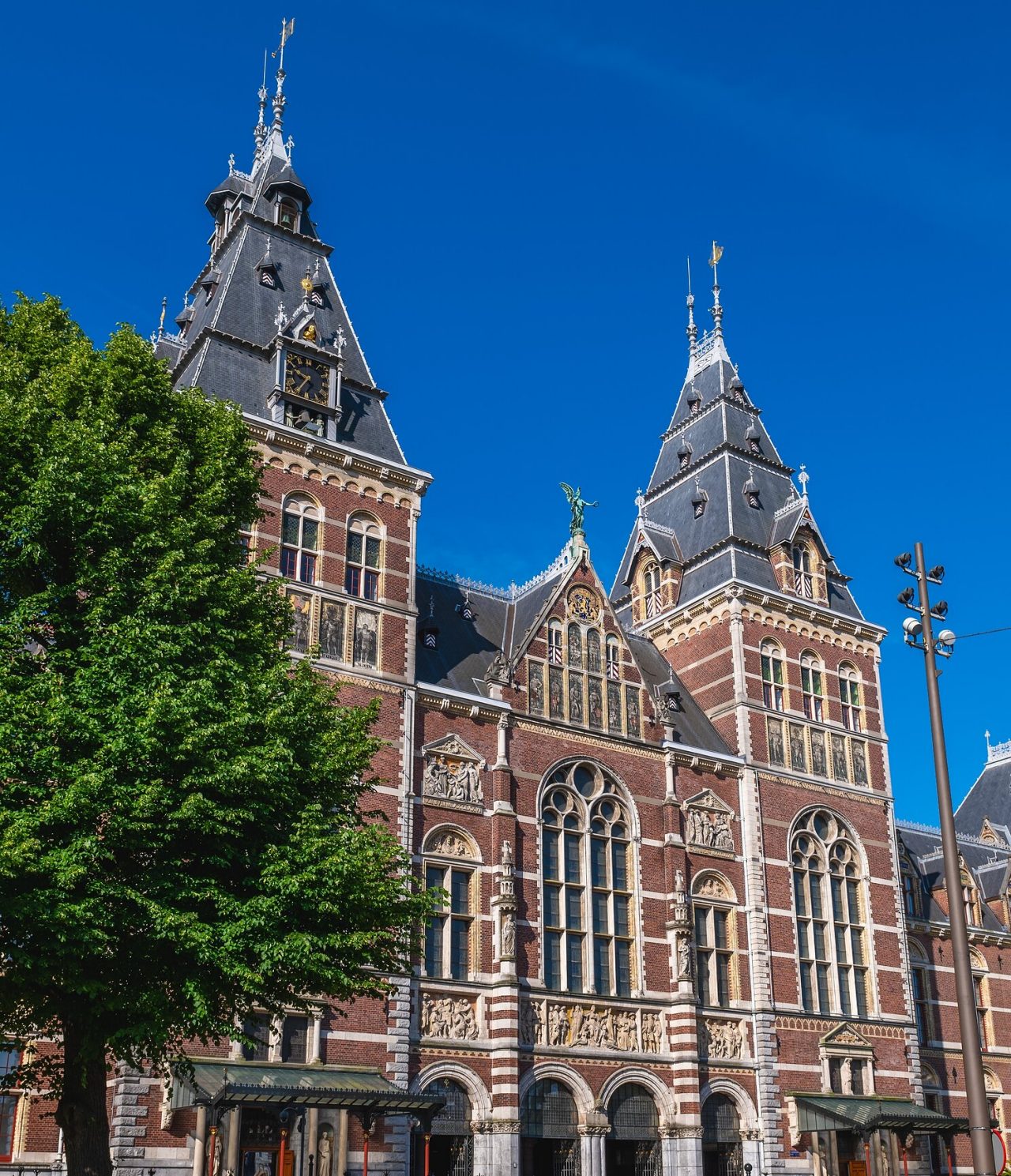 Vista frontal del Rijksmuseum en Ámsterdam, con su arquitectura gótica renacentista y dos torres prominentes