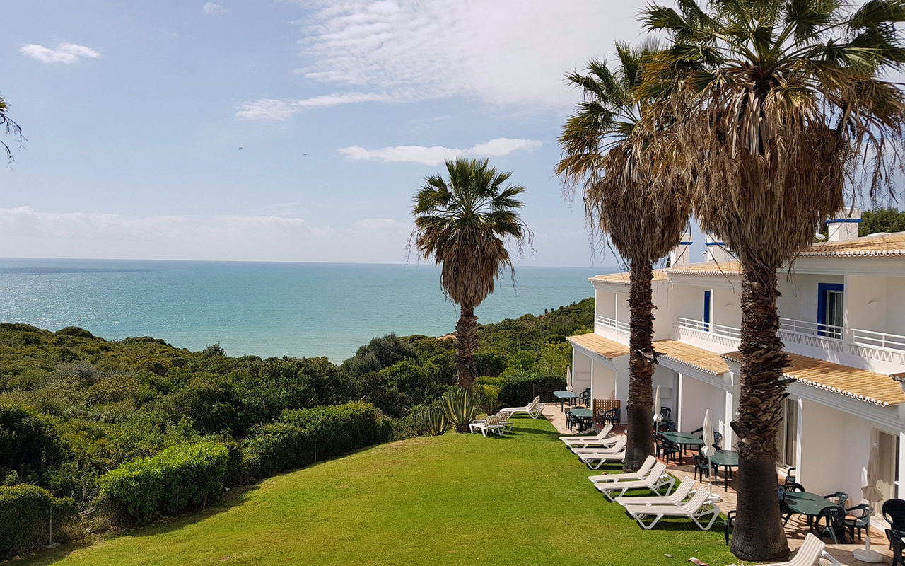 Villas en Pestana Palm Gardens en Carvoeiro, con jardín y palmeras al frente y vista al mar y horizonte