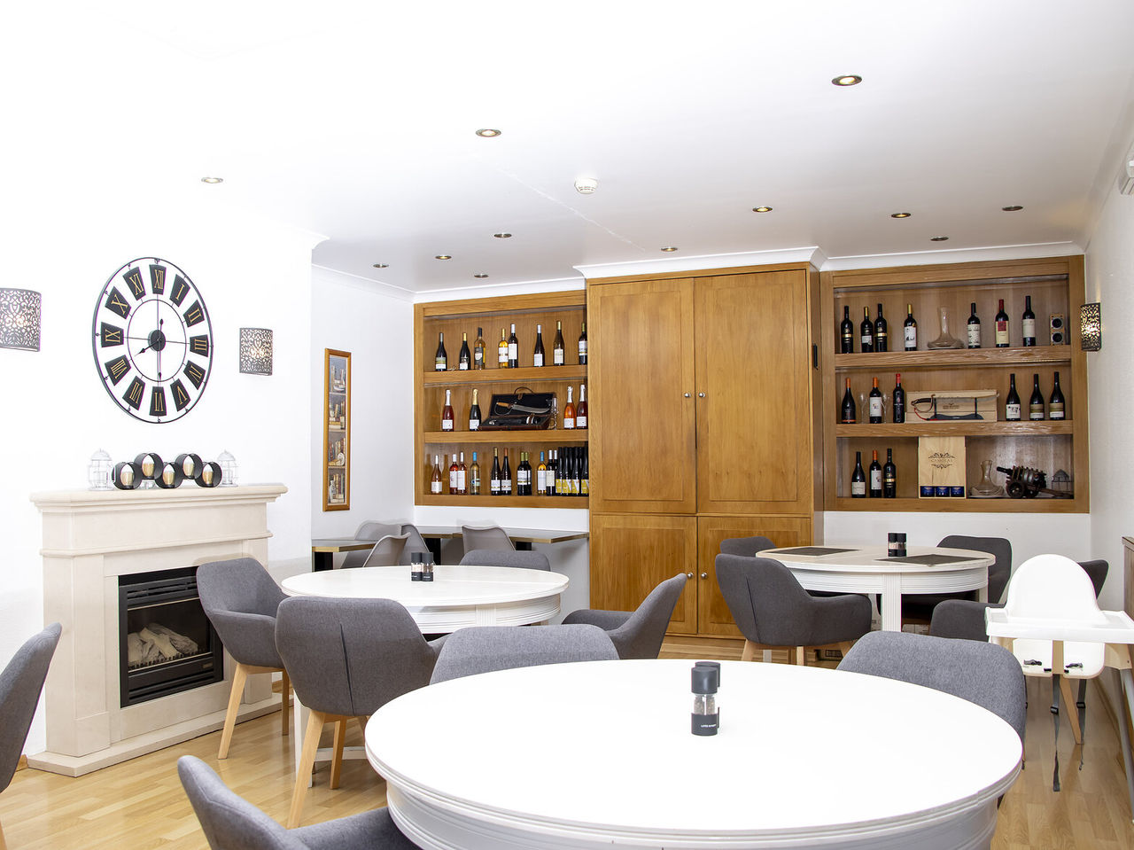 El restaurante Sal & Tal, del Hotel 4 Estrellas en Carvoeiro, Algarve, tiene mesas redondas y un armario con varios vinos