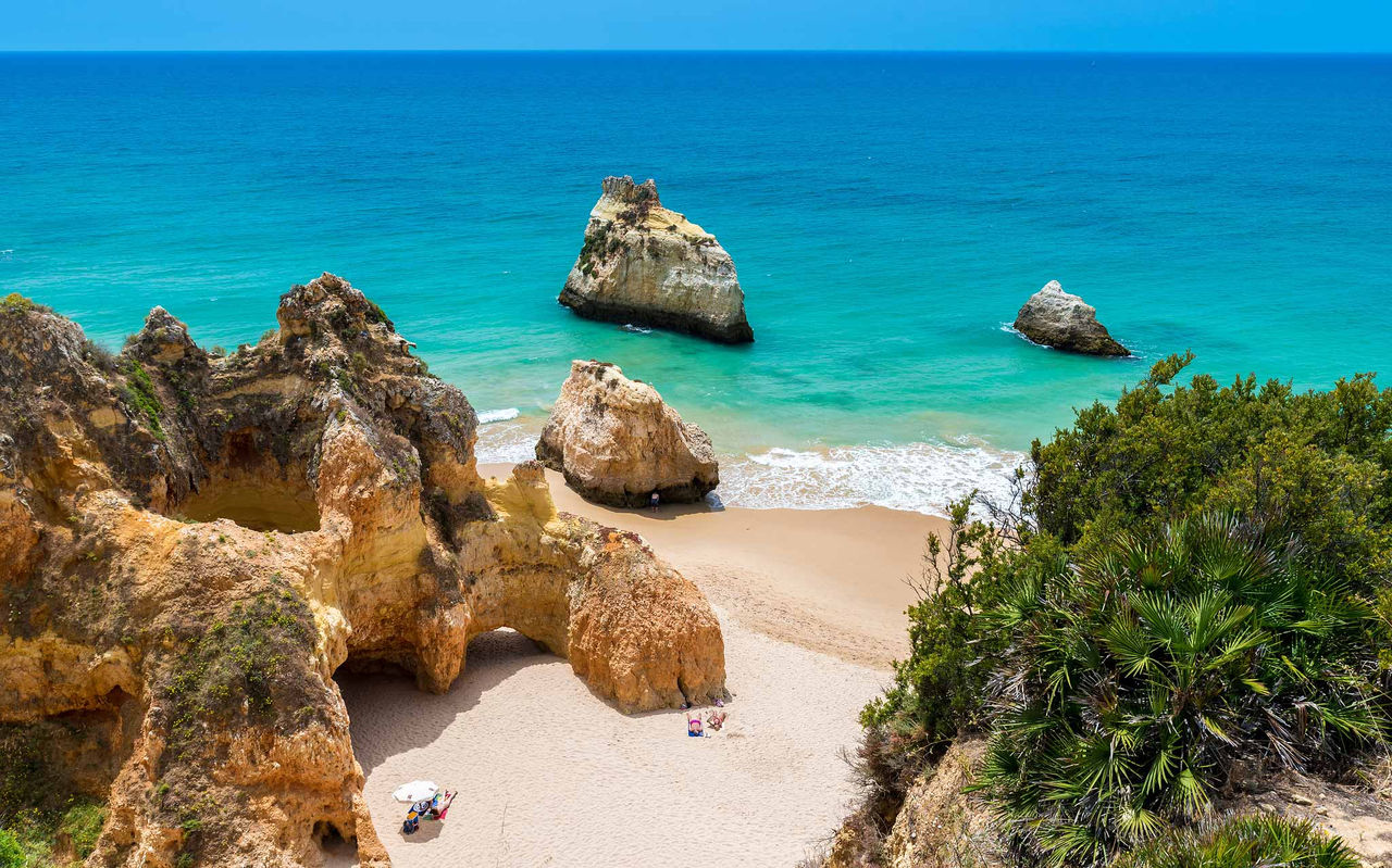 Explora Hoteles en Alvor, Algarve con vistas a acantilados dorados y playa de aguas turquesas del Atlántico
