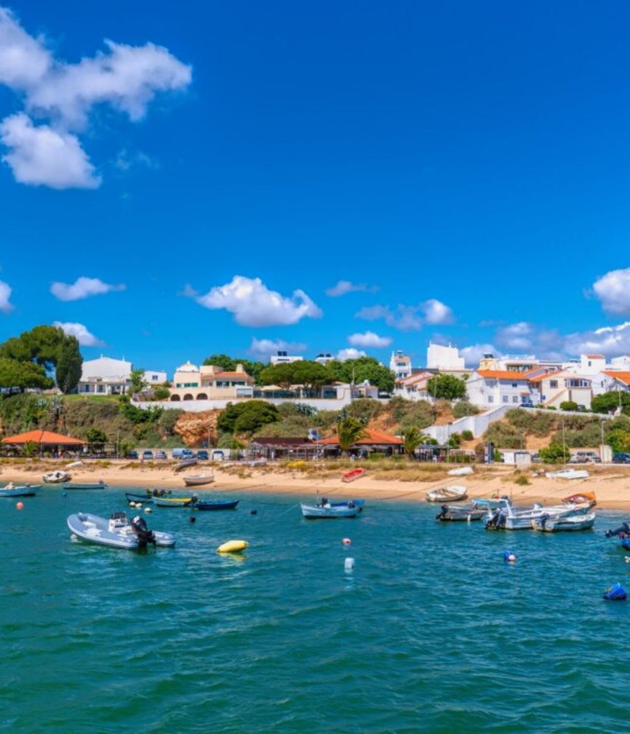 Explora Hoteles en Alvor, Algarve con vistas a pequeñas barcas frente a la costa y casas bajo cielo azul