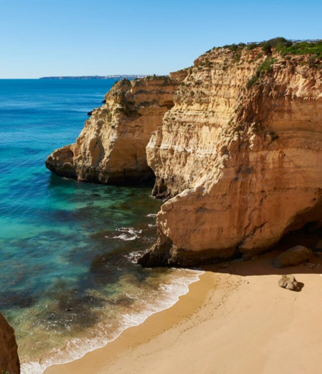 Explora Hoteles en Alvor, Algarve con vistas a acantilados dorados y playa de aguas turquesas cristalinas