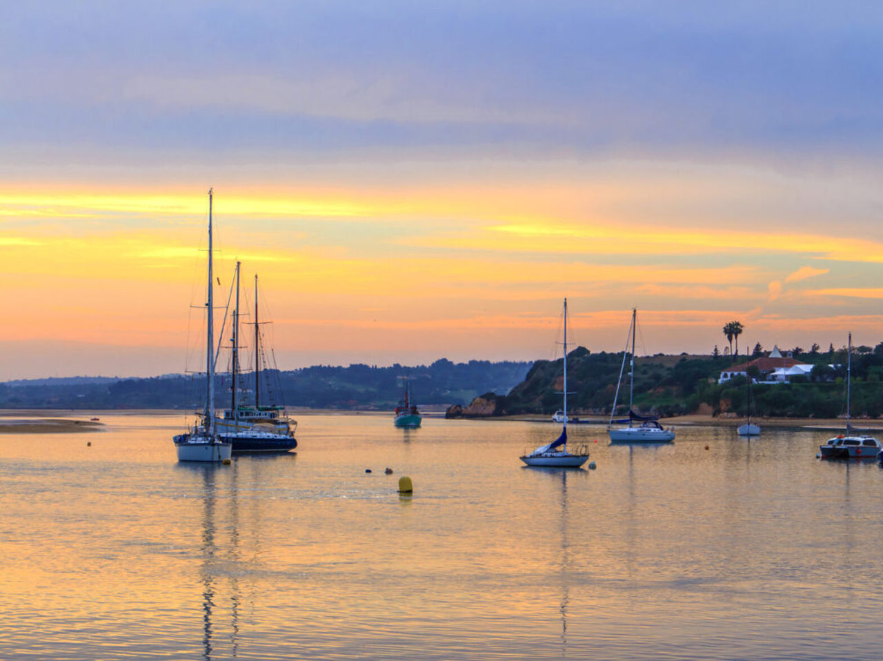 Explora Hoteles en Alvor, Algarve con vistas a veleros fondeados sobre aguas tranquilas al atardecer