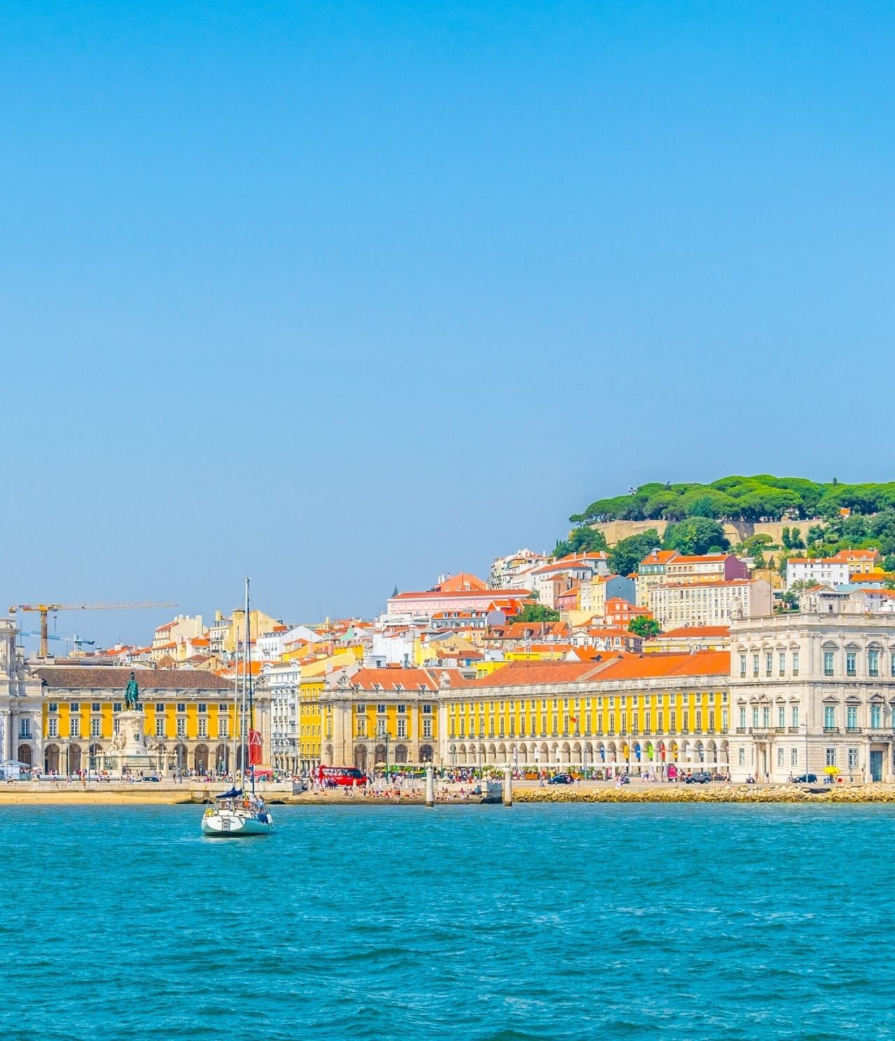 Explora Hoteles en Lisboa con vistas al paseo marítimo y edificios históricos junto al río Tajo azul