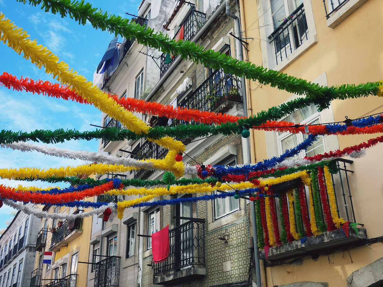 Explora Hoteles en Lisboa con calles decoradas con guirnaldas coloridas y balcones tradicionales