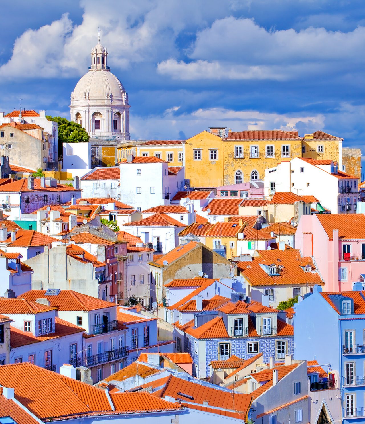 Explora Hoteles en Lisboa con vistas a tejados rojizos y la cúpula histórica entre nubes sobre la ciudad