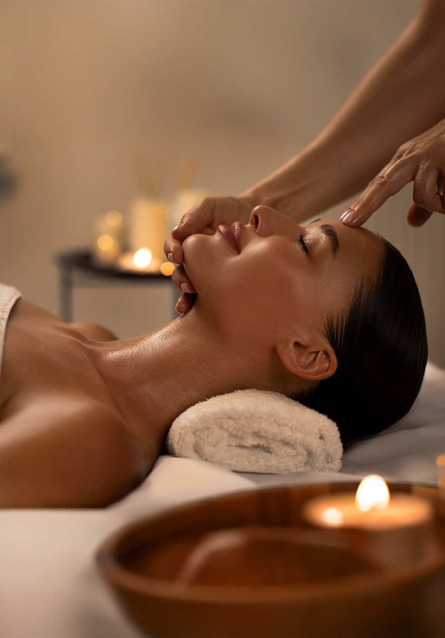 Ritual facial de aromaterapia en spa con masaje relajante, velas encendidas y ambiente cálido y sereno
