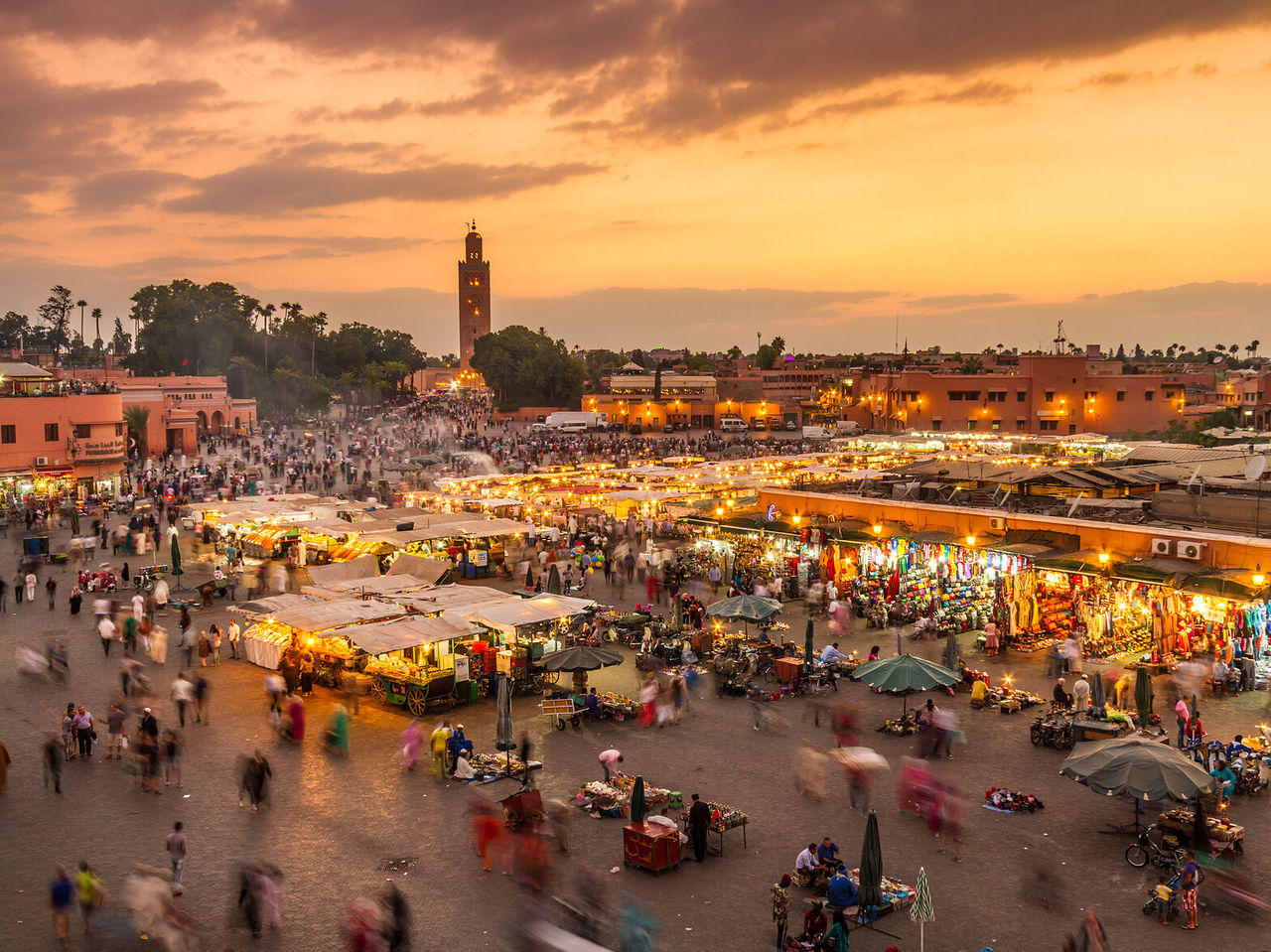 Vue de dessus de la place principale du centre historique de Marrakech, la nuit, avec des tentes et des boutiques éclairées