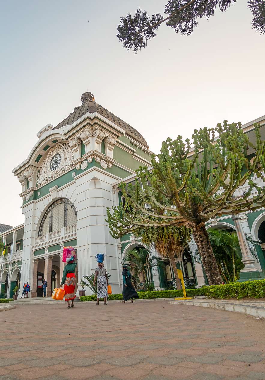 Des gens se rendent à la gare de Maputo, un monument historique de la ville avec une architecture classique
