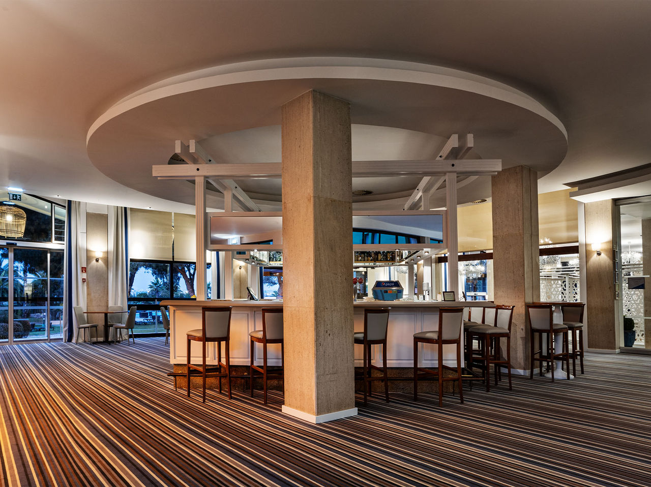 Le bar do Princípe de l’hôtel en Algarve a un espace vaste avec plusieurs chaises hautes et un bar pour les boissons