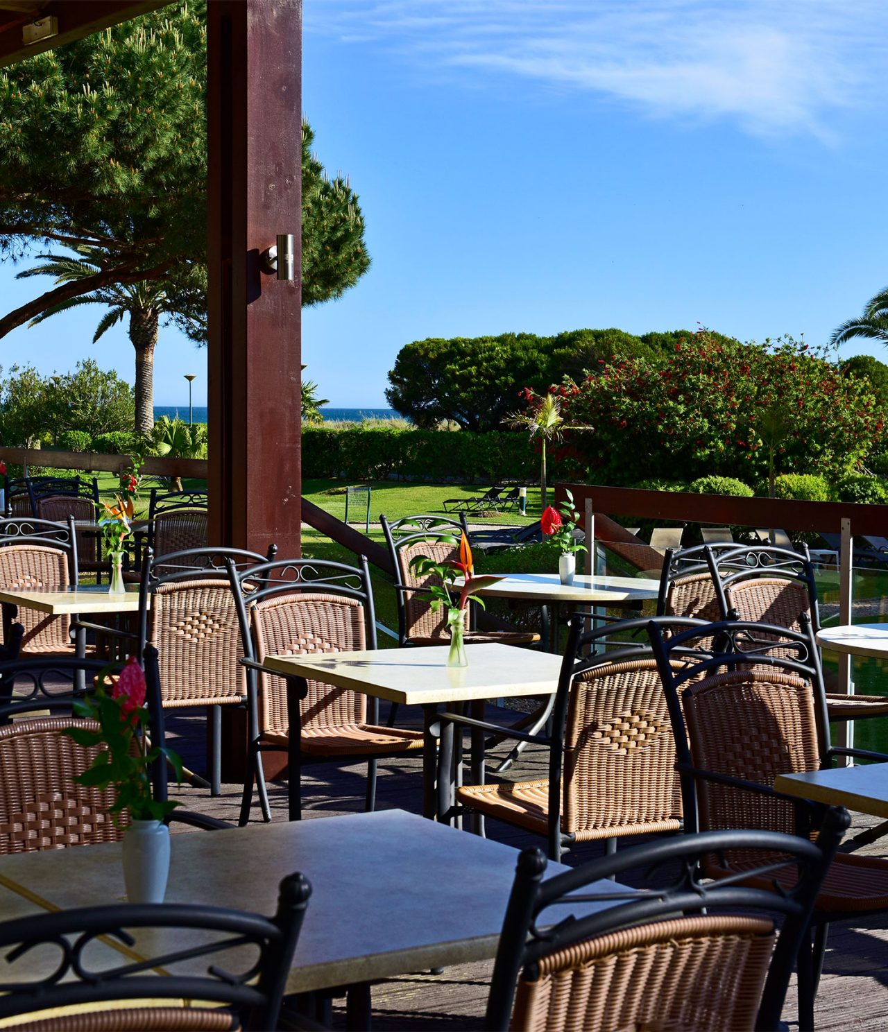 Le restaurant Pavilhão do Rei de l’hôtel en Algarve a plusieurs tables en extérieur avec vue sur le jardin et la mer