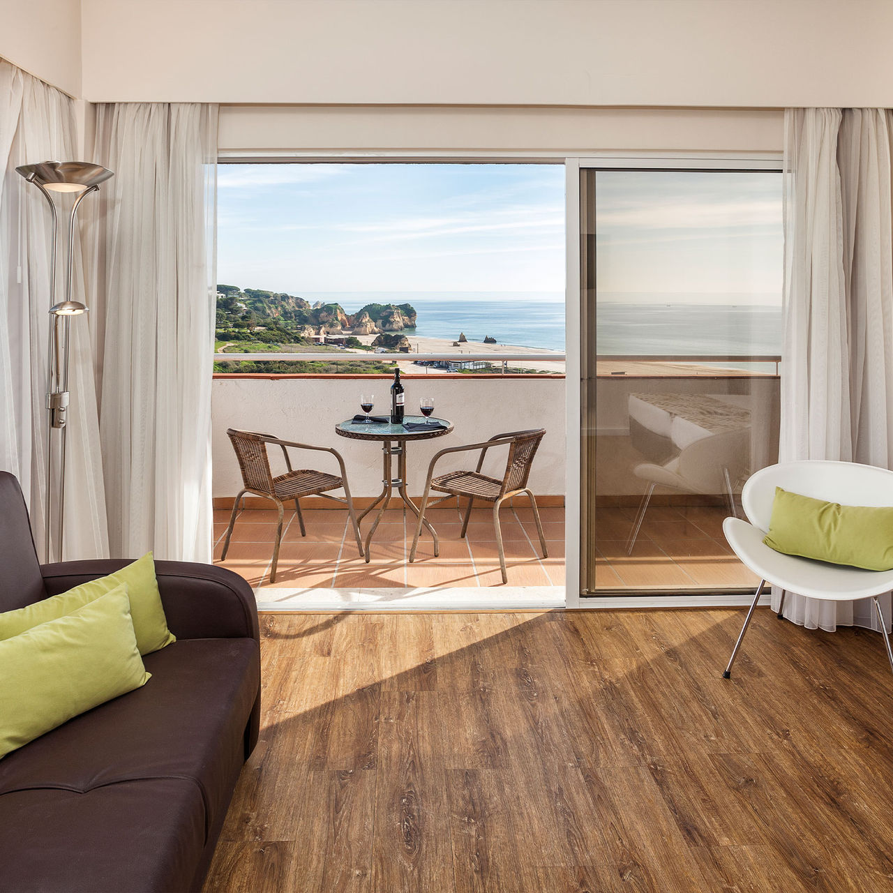 Vue d'un appartement au Pestana Alvor Atlântico, avec balcon sur la mer et deux verres de vin