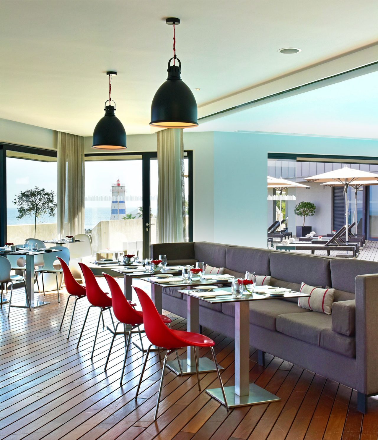Le restaurant Maris Stella de l’hôtel 5 étoiles à Cascais a un canapé gris avec des tables et des chaises rouges