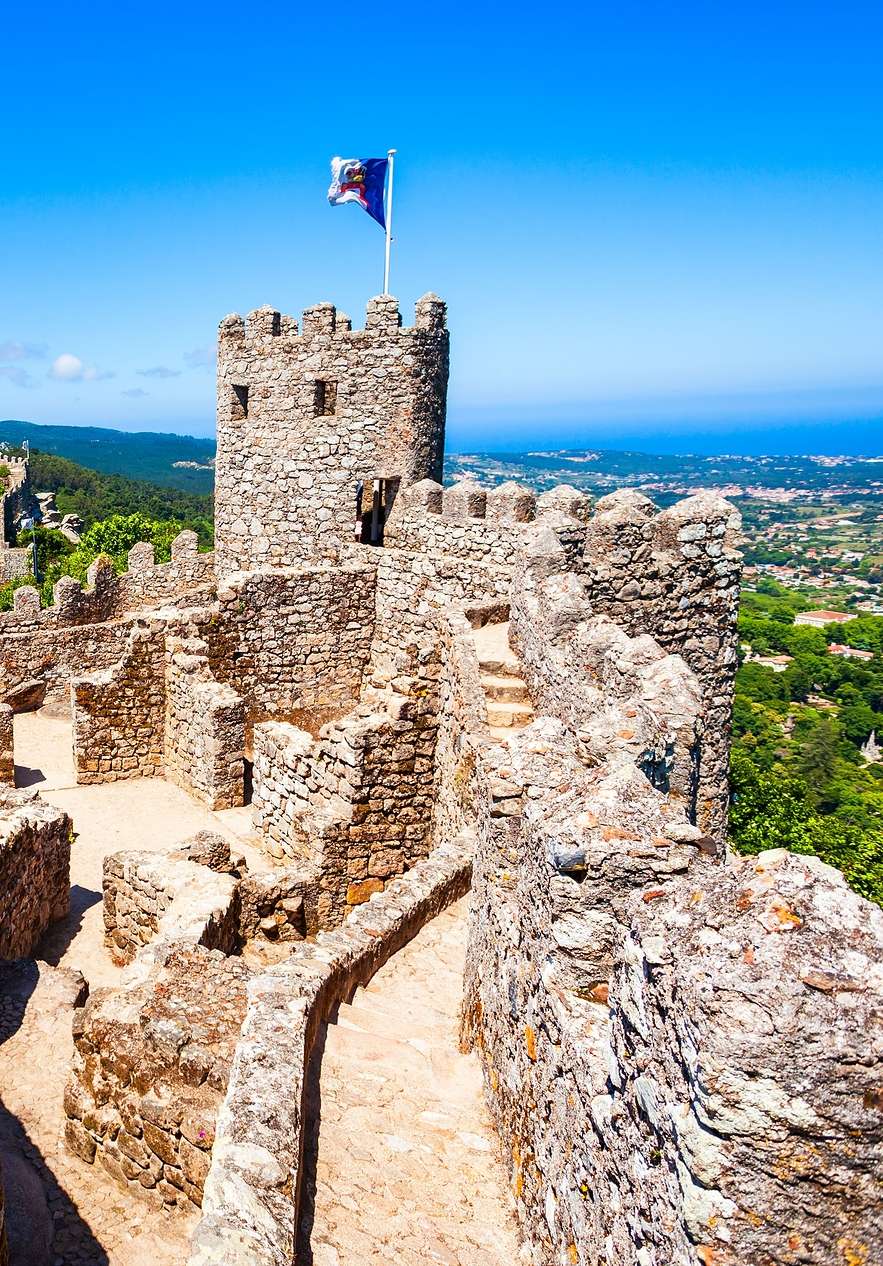 Vue panoramique du Château des Maures à Sintra, avec des murs en pierre, des tours et un paysage magnifique