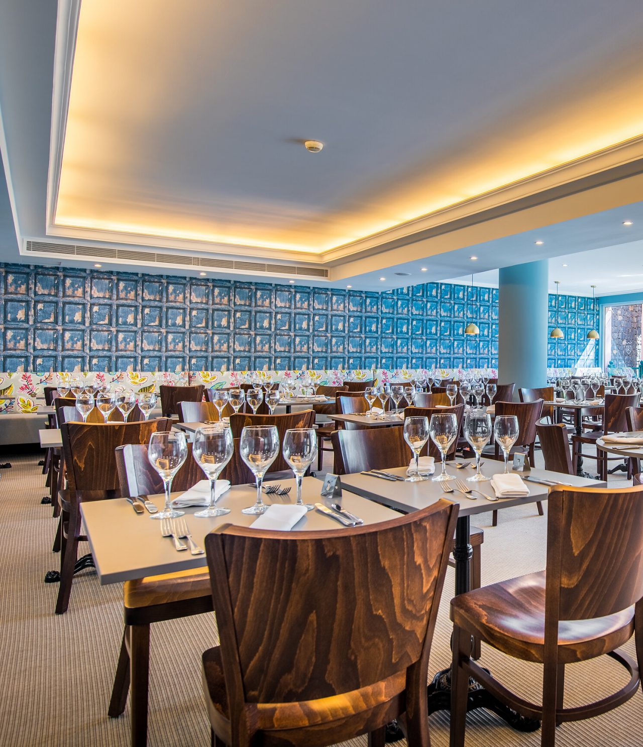 Le restaurant Campo de Fiori, de l'hôtel 5 étoiles à Funchal, a espace large, murs colorés, tables et chaises