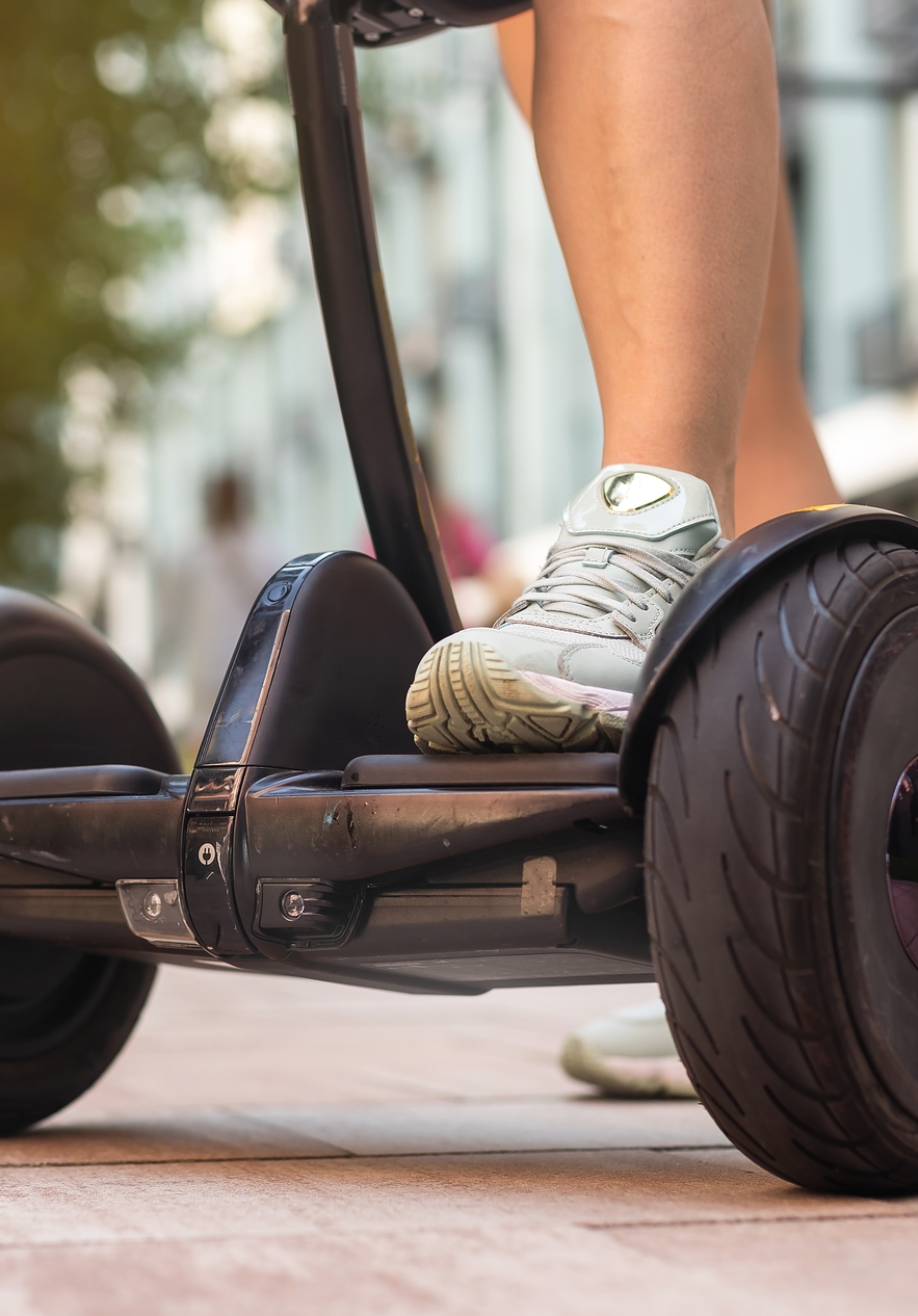 Personne avec les pieds sur la base d'un segway sur un chemin pavé