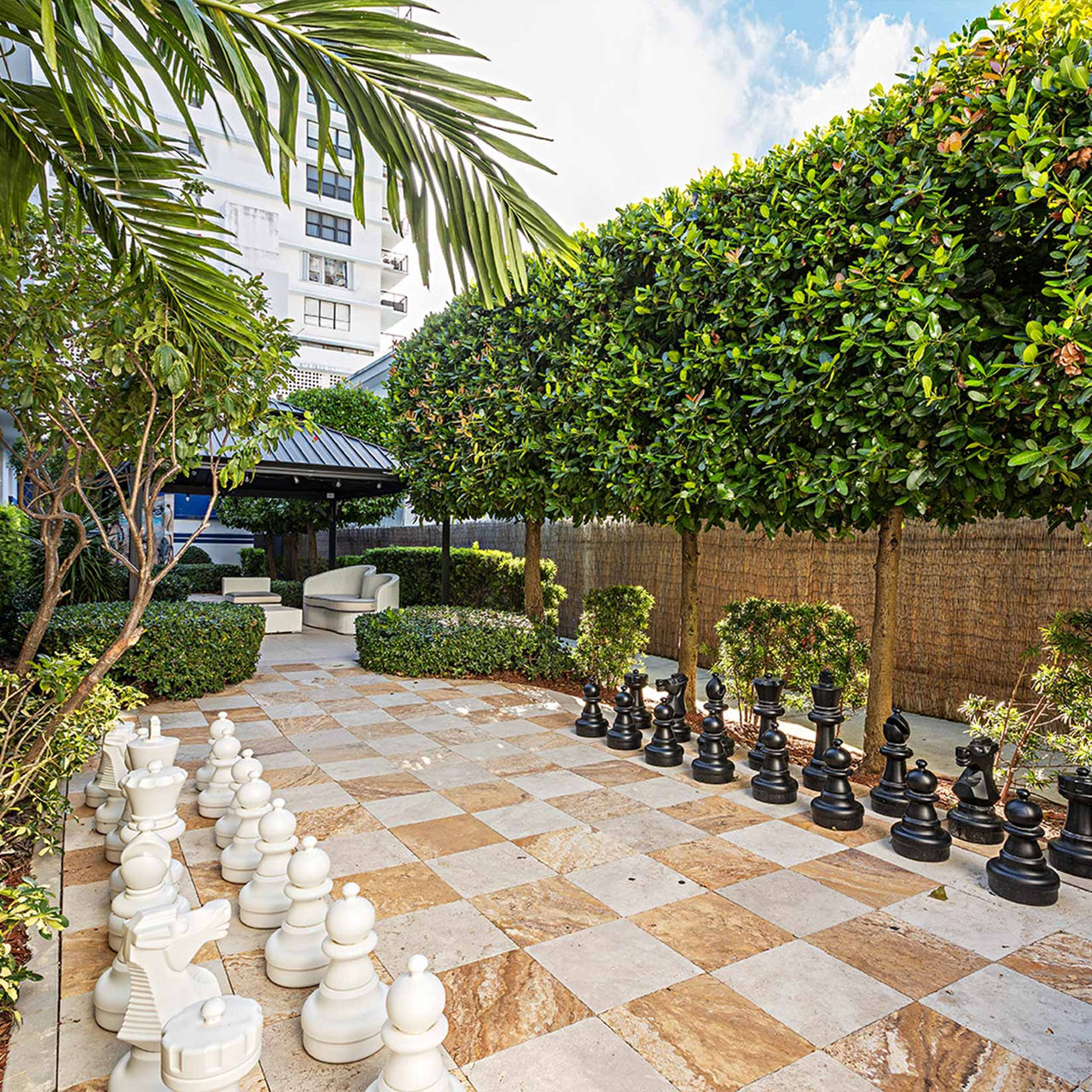 Pestana South Beach Miami, Hôtel Boutique à Miami avec échiquier géant sur une terrasse bordée d'arbres