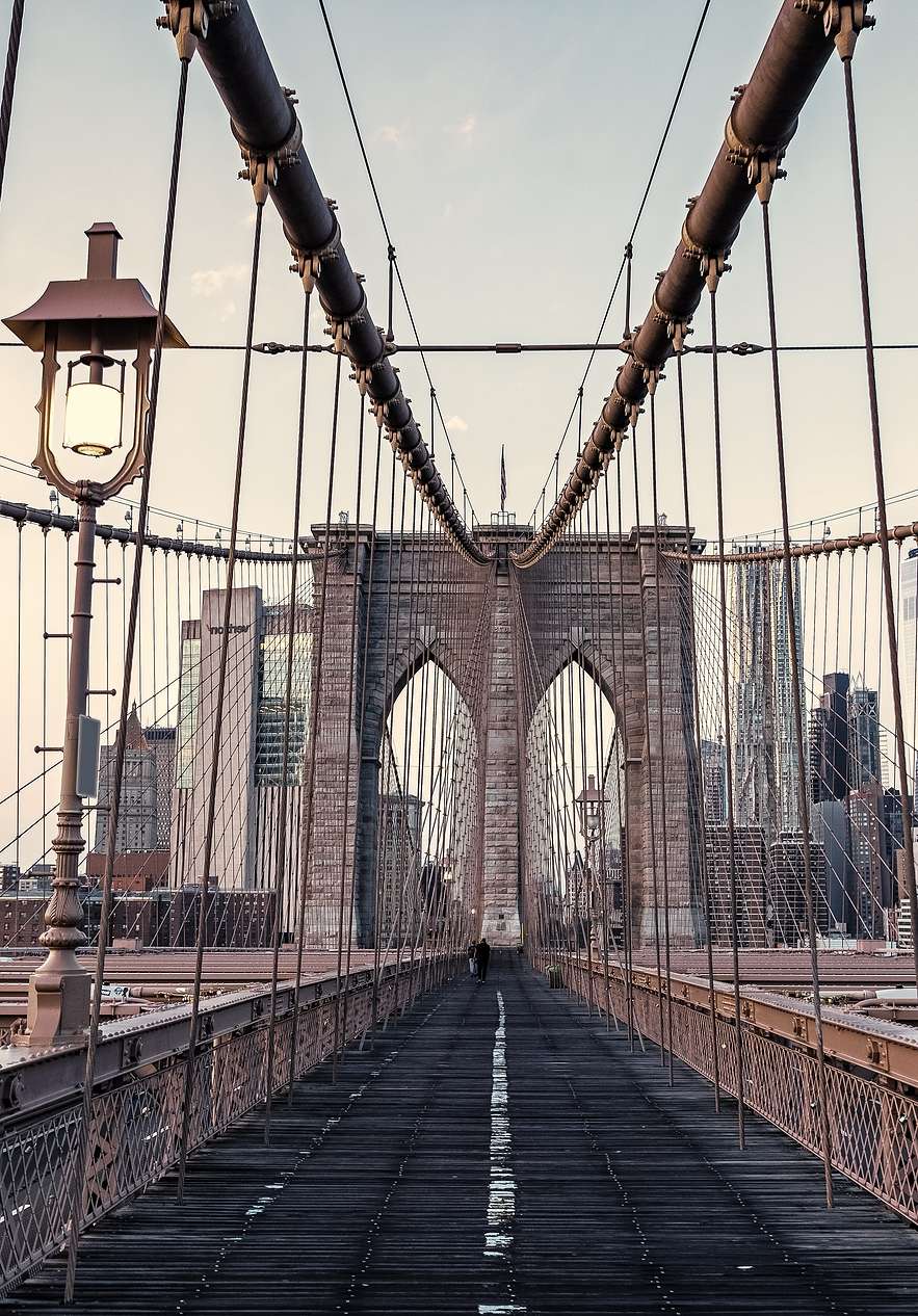Vue panoramique du pont de Brooklyn, avec ses câbles d'acier et structure en fer, sous un ciel bleu clair