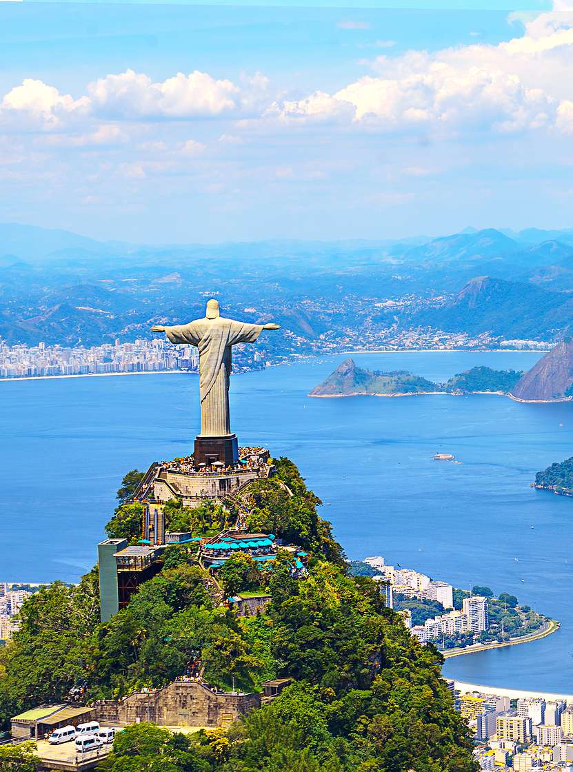 Statue emblématique du Christ Rédempteur à Rio de Janeiro, avec la ville, l'océan et la plage en arrière-plan
