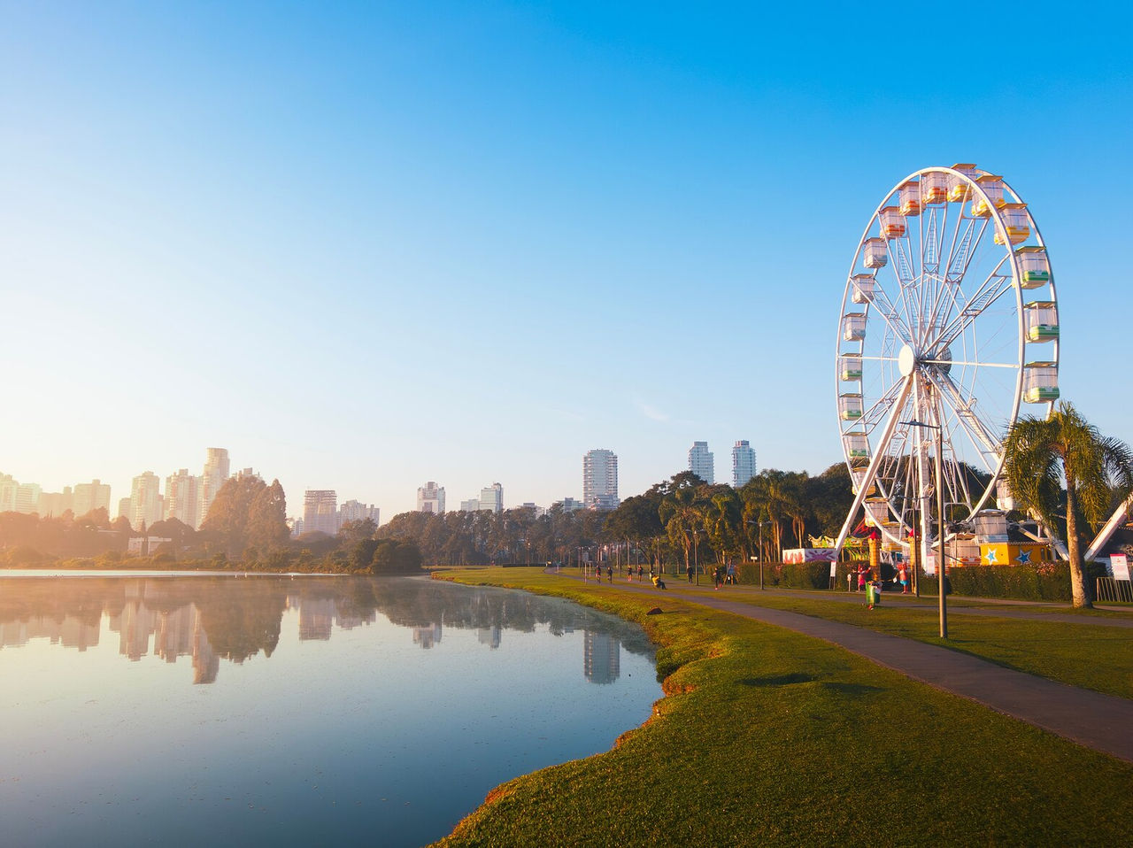 Vue pittoresque avec la grande roue de Curitiba, lac, et ville en arrière-plan par une journée ensoleillée