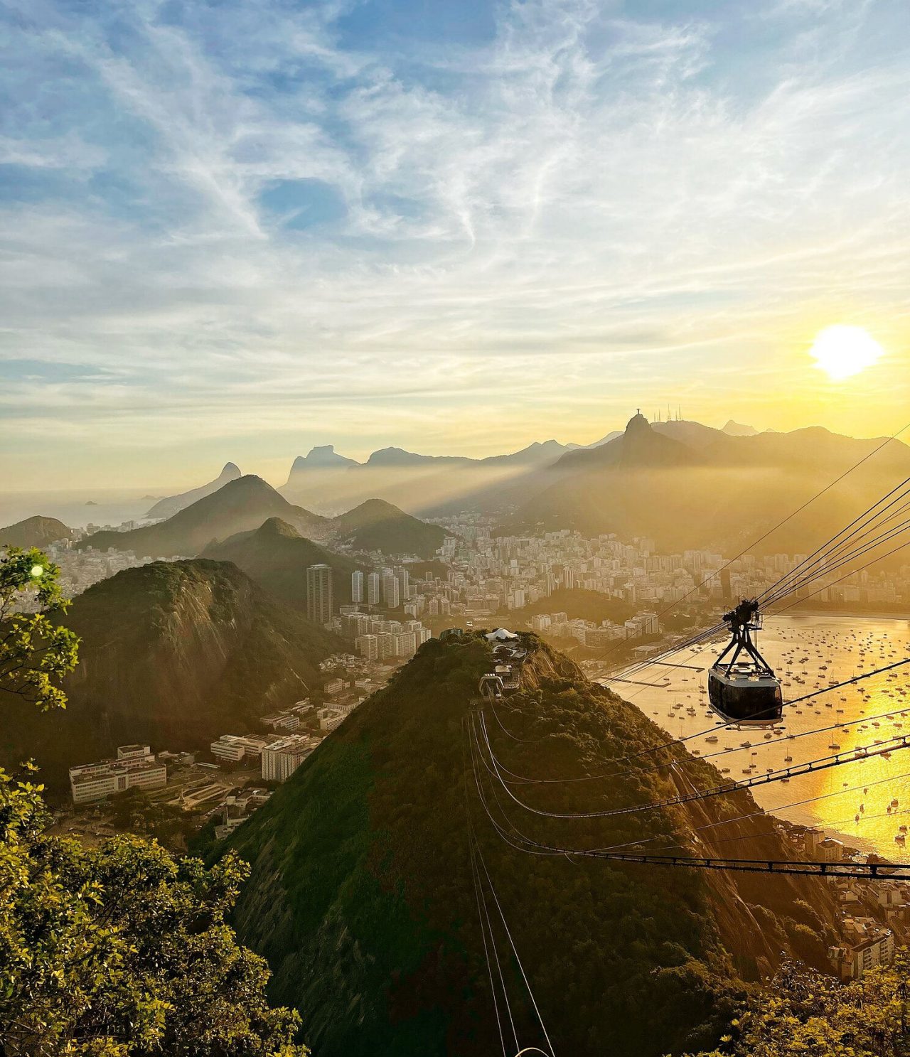 Vue aérienne de Rio de Janeiro, avec un téléphérique se dirigeant vers une colline, avec la ville et la plage en arrière-plan